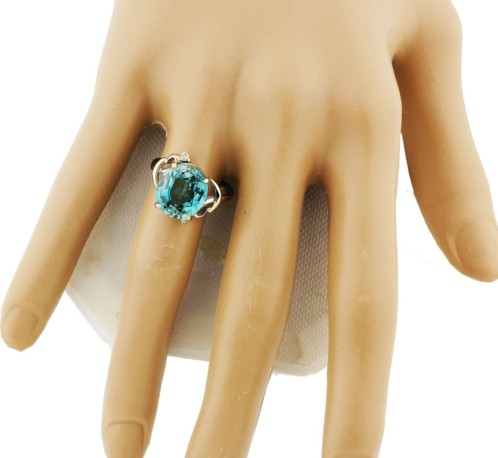 Set in a unique handmade 14Kt white gold ring enhanced with two tiny diamonds this beautiful glistening translucent blue Zircon is 7.8 carats of glittering beauty.  the ring is a size 7 (sizable)  