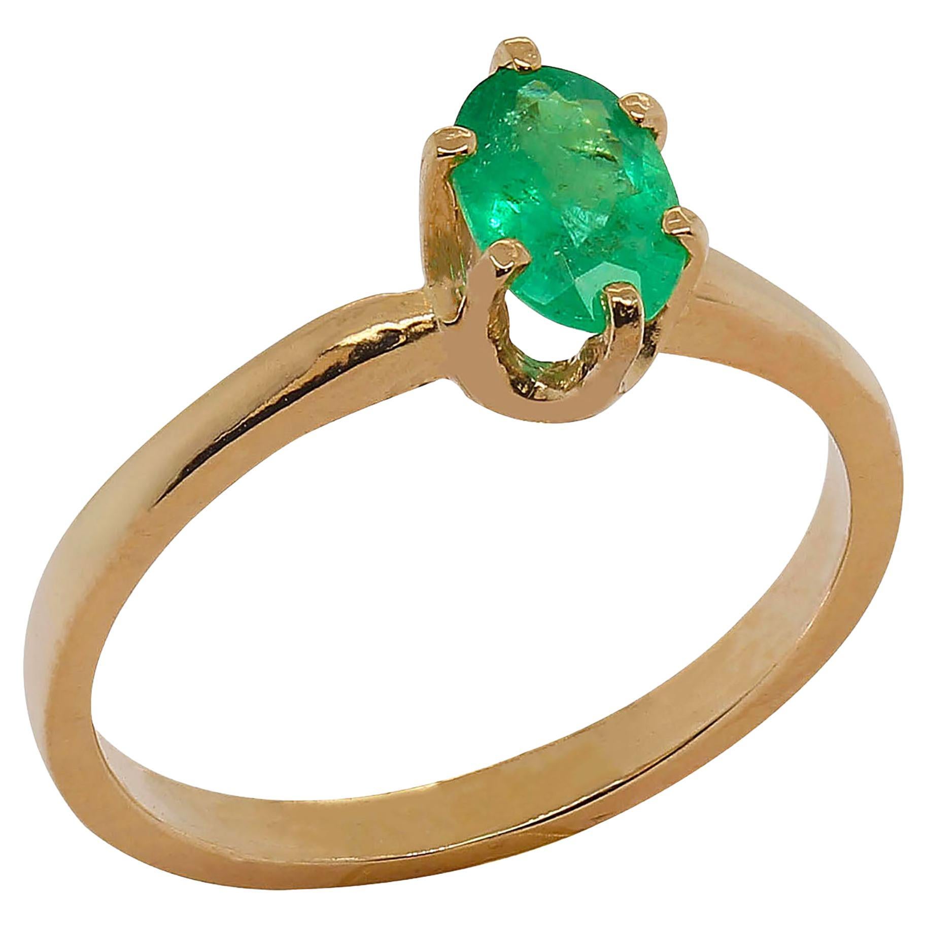 Oval, Brazilian Emerald in classic six prong 14k yellow gold ring.  Beautiful, sparkling Emerald with the bright green 'Brazilian look.'  This is such a lovely Emerald, it has all the typical properties of the best Brazilian Emeralds. O.56 carats.