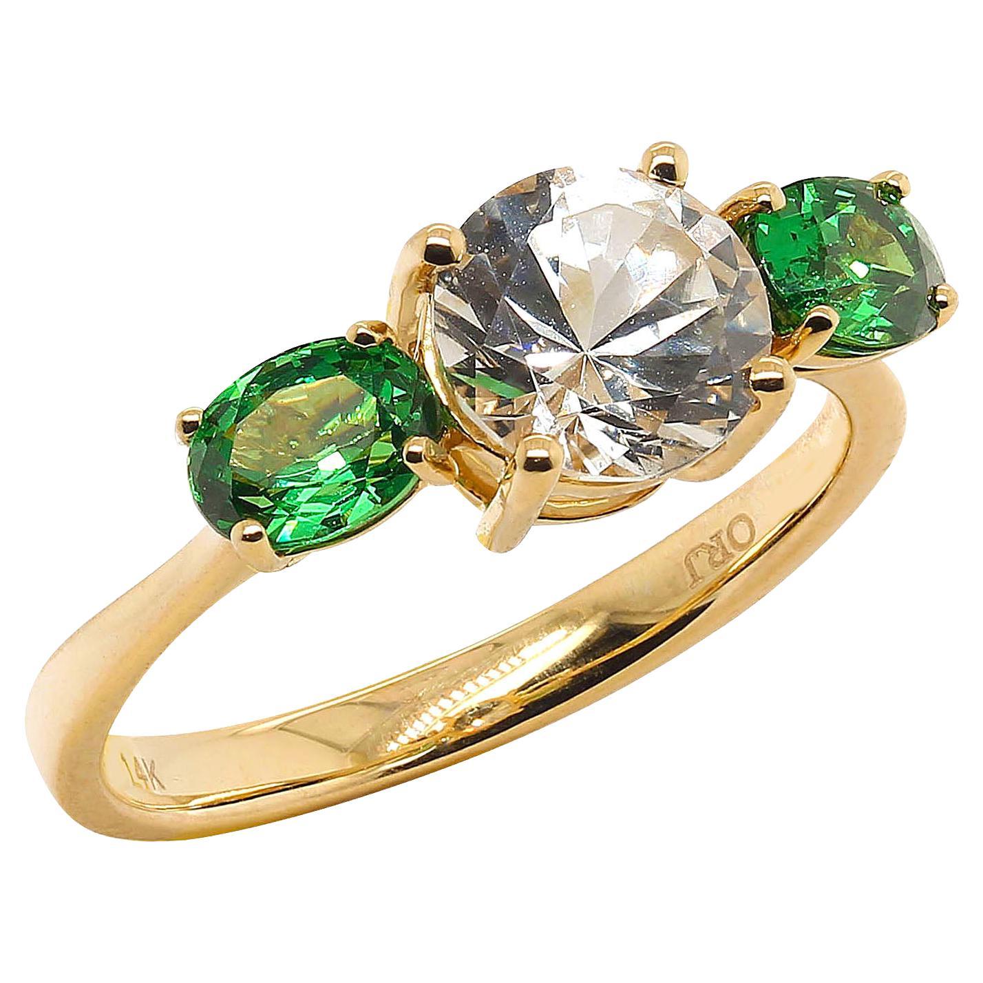 Custom made, romantic 14K Yellow Gold Ring featuring a sparkling, round White Sapphire flanked by two brilliant oval, green Tsavorites. This traditional ring is such a romantic look. The sparkling White Sapphire is 1.65 carats and the two brilliant