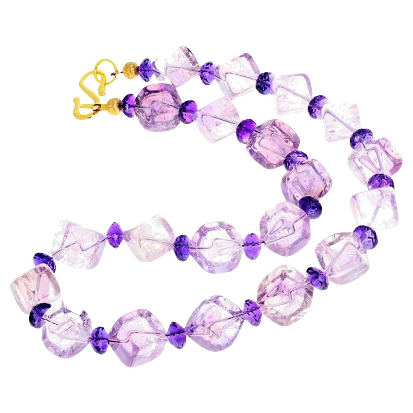 Cubes of translucent Rose of France Amethysts (approximately 12 mm x 12 mm) are enhanced with glittring checkerboard gem cut Amethyst rondels. This necklace is 18.75 inches long with a gold washed hook clasp. Spectacular optical effect in the Rose
