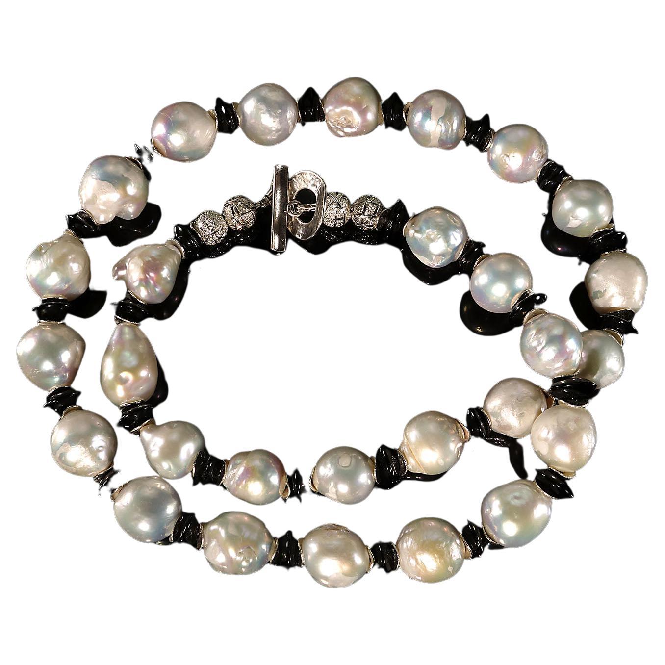 Own the jewelry you wish for

Stunning necklace of white Baroque Pearls and glistening Black Tourmaline rondelles with silver tone flutter accents.  This unique black and white necklace is 25 inches in length and is secured with a Sterling Silver