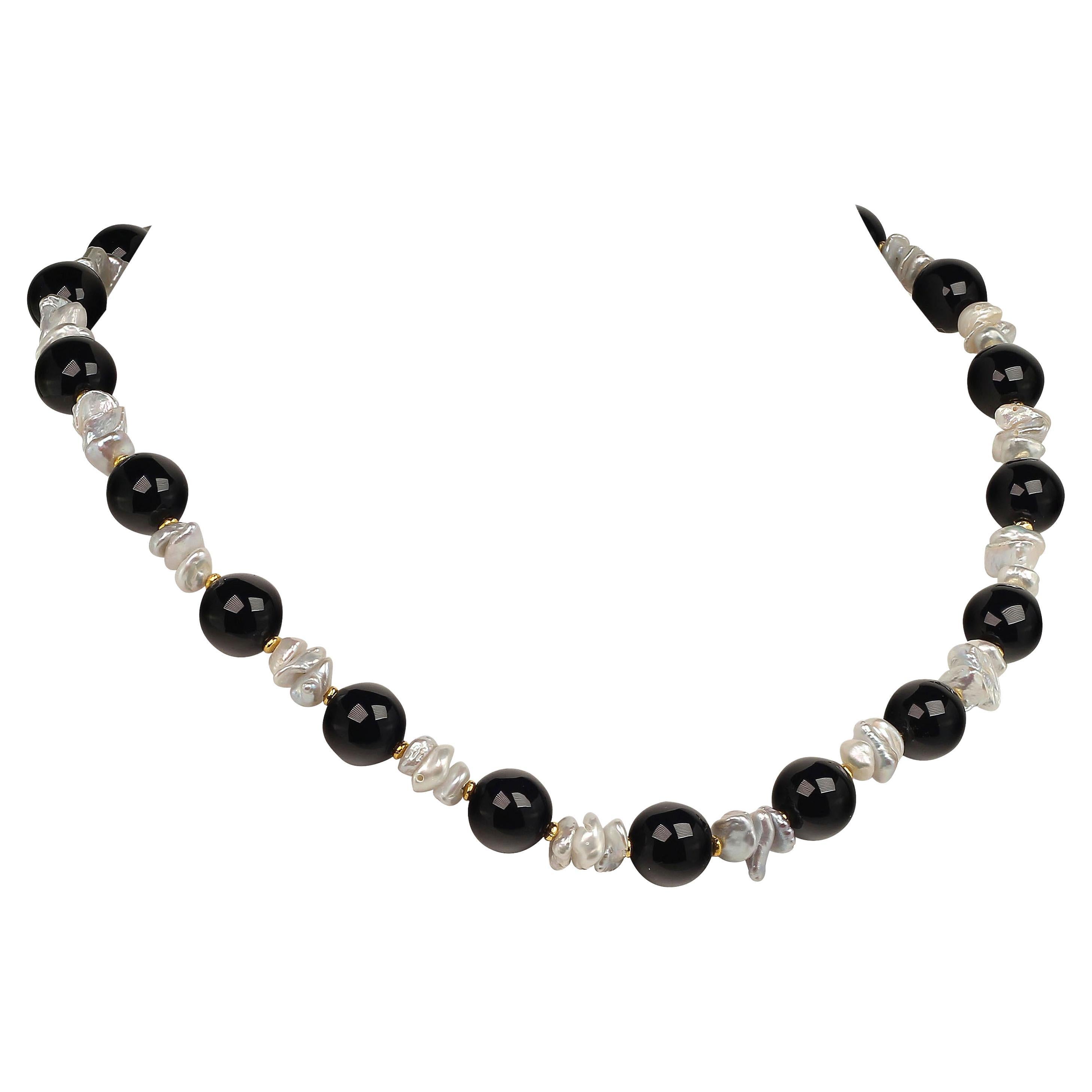 Own the jewelry you desire

Elegant necklace of glistening Black Onyx (12MM) and iridescent White free form Pearls with gold tone accents.  This unique 18 inch necklace is perfect for all occasions and will enhance any ensemble.  It is secured with