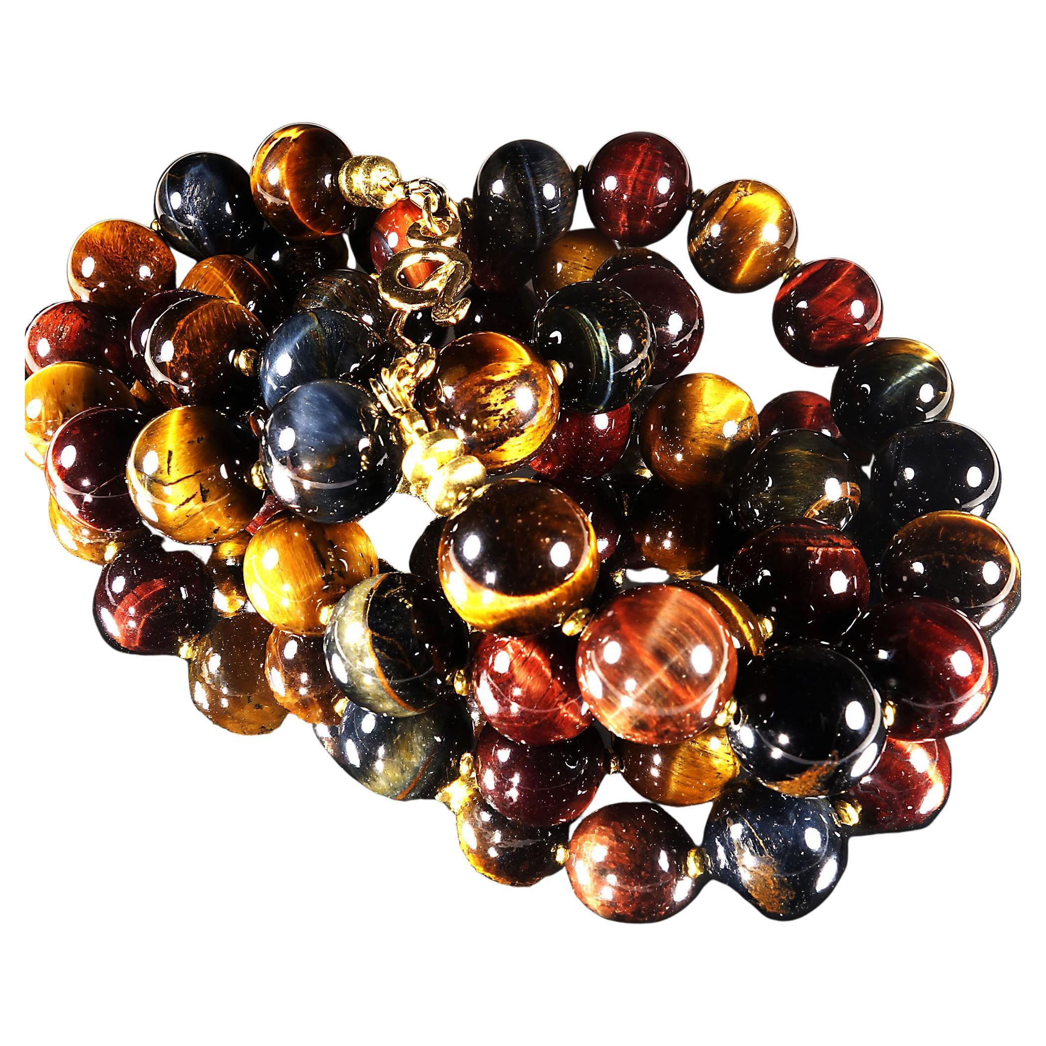 Handmade, 29 inch long multi color Tiger's Eye necklace.  This unique necklace features red, blue, gray, and golden Tiger's Eye all in 14MM rounds.  The Tiger's Eye is enhanced with gold tone rondels.  This is the perfect length to sit underneath a