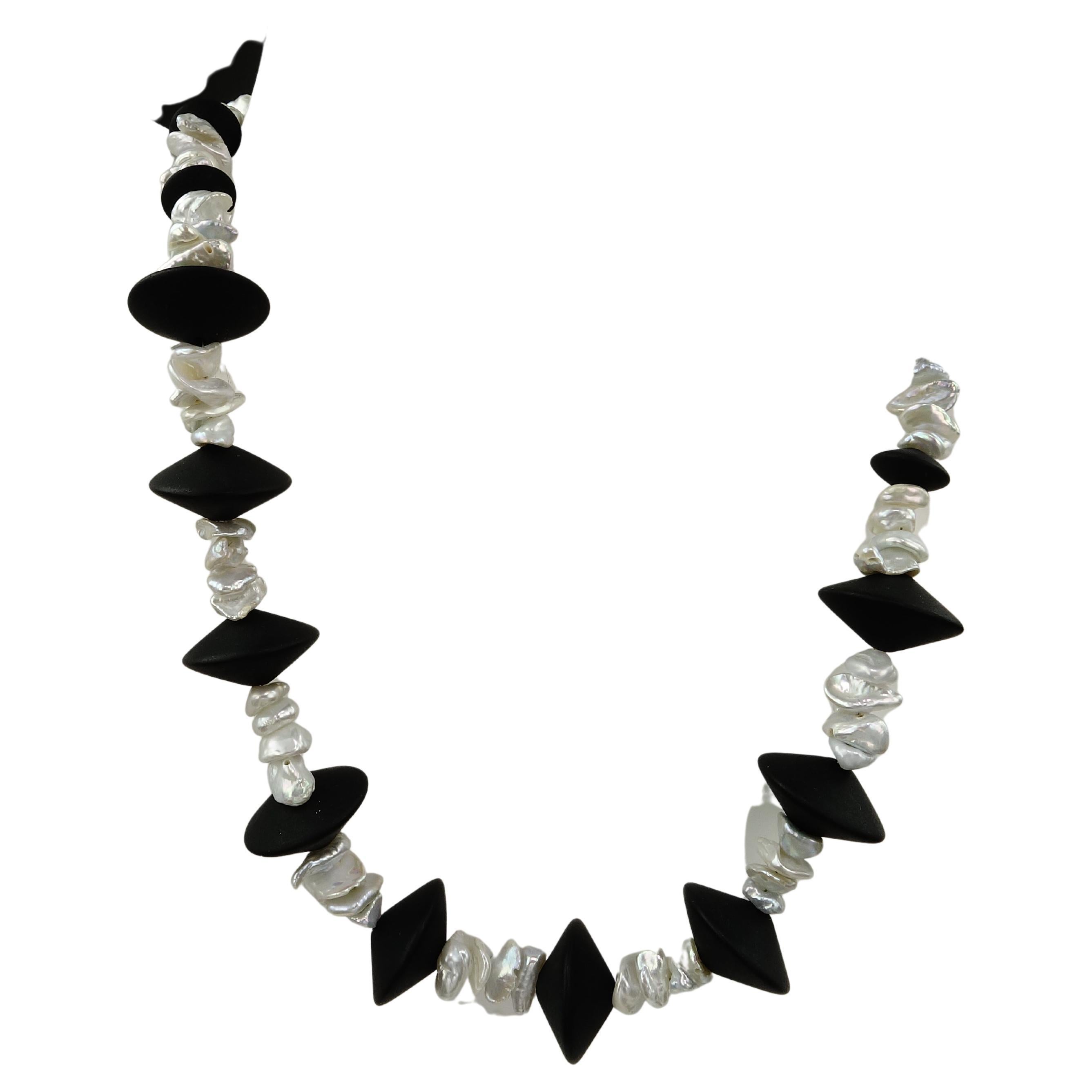 16 Inch Choker necklace of Matte Rondelle Black Onyx and shimmering silvery Biwa pearls.  This contrast between the Pearls and Black Onyx makes a striking choker necklace.  At 16 inches this unique piece sits at the base of the neck. It is secured