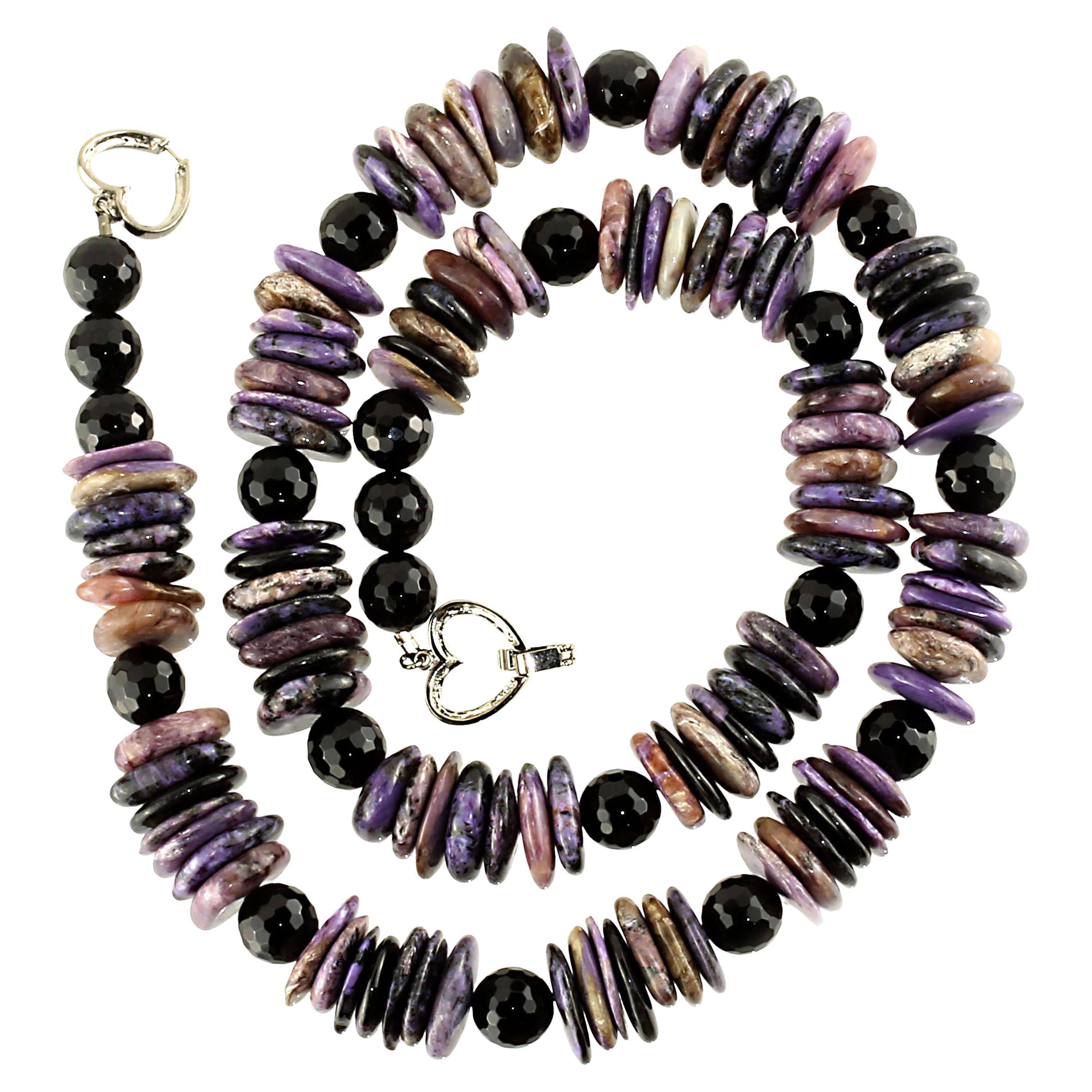 Handmade beautiful purple Charoite in Matrix necklace. The highly polished Charoite is thinly sliced and spaced with faceted onyx spheres. This statement necklace is 25 inches in length. It features a double sided silver plate heart clasp.