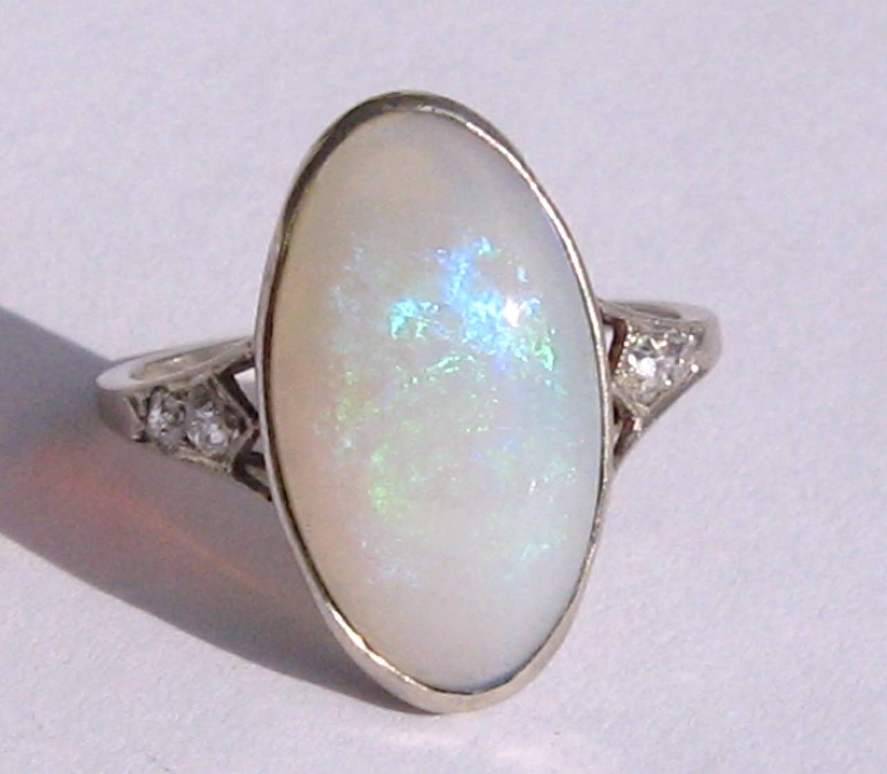 Pictures don't do this opal justice, wonderful fire in this Large oval opal
Two accent diamonds flank both sides of the shank
Bezel set 
Ring is a size 6.5 and can be sized by your jeweler or us

Measures 
.71