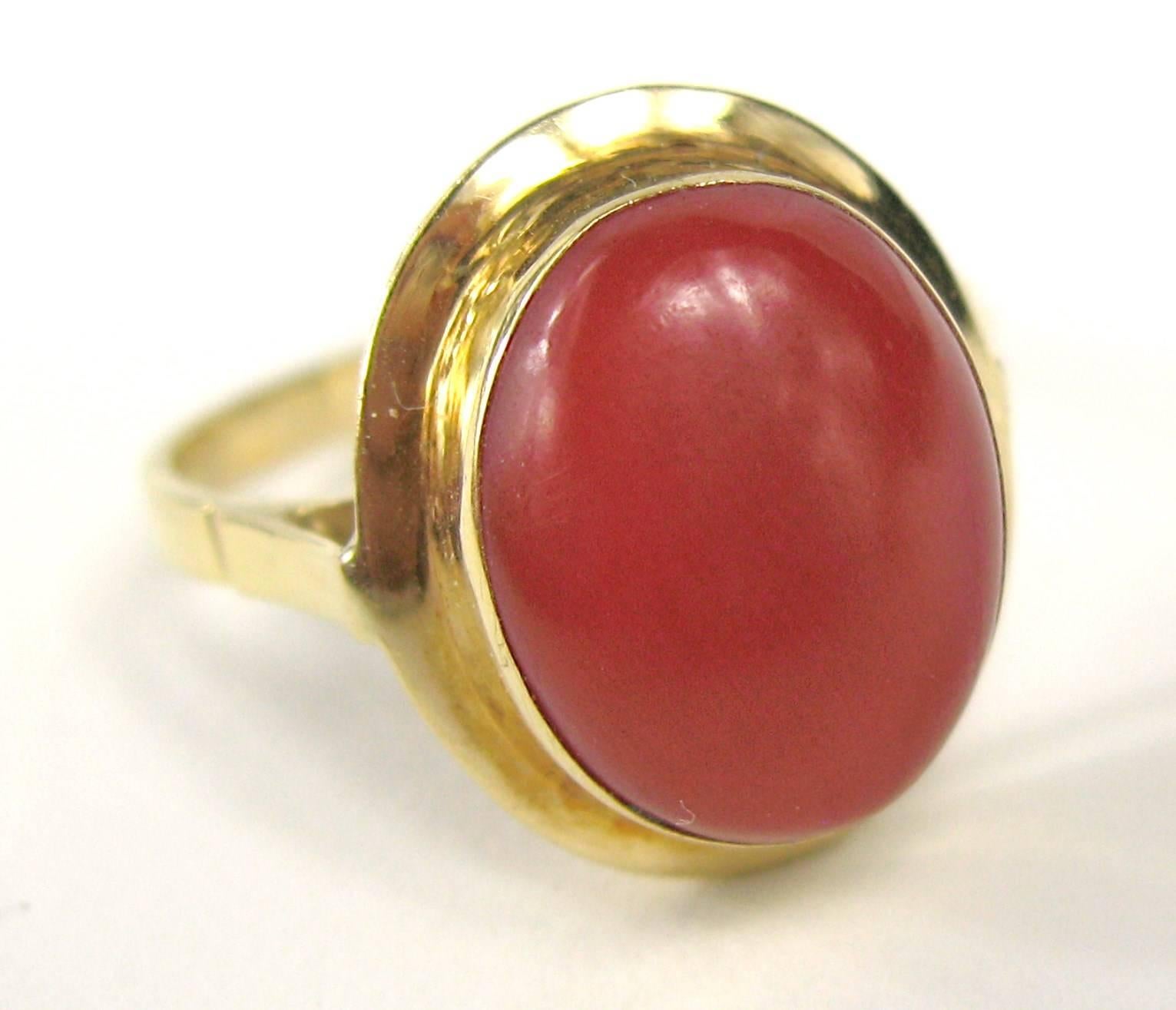 Red coral set in 18k yellow gold ring. Hallmarked 18K inside shank. Red genuine coral cabochon measures 12.80mm x 10.50mm x 5.20mm 5+ Carats. Ring is a size an 8.5 and can be sized by us or by your jeweler. Be sure to check our store front for more