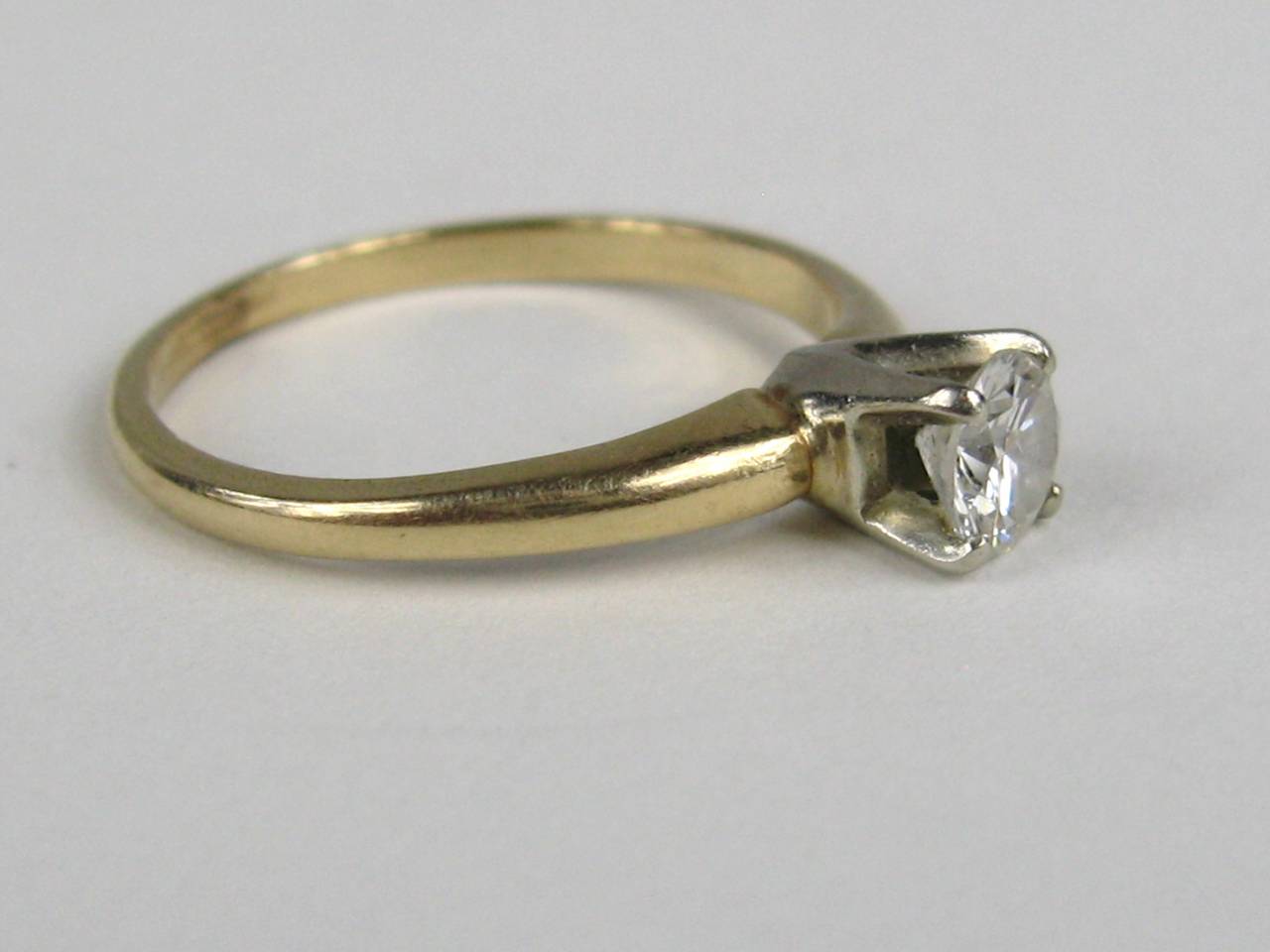 Solitaire Diamond set in 14K Yellow Gold with One Round Brilliant Cut Diamond that is a .50 Carat - SI-1 Color F-G and a Size 7.25 which can be sized by us or your jeweler. This is out of a massive collection of Contemporary designer clothing as