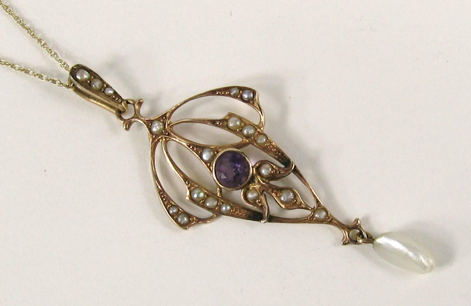 Superb Victorian era lavalier circa 1860s crafted beautifully in 14k yellow gold. Center is a bezel set Amethyst with delicate seed pearls scattered. 1 Dangling seed pearl. Measuring 1.82 inches top of bale to seed pearl. On a delicate 14k gold