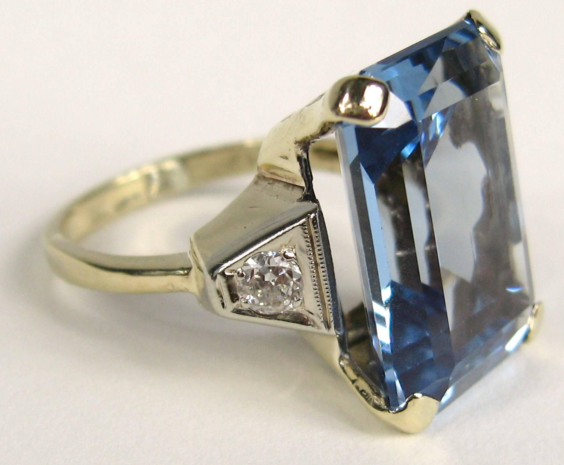 This is exquisite. Large Emerald Cut Blue Topaz Ring flanked by diamonds on either side. Set in 14K yellow and White Gold, Ring is a size 6.5 and can be sized by us or your jeweler. The Topaz is approximately 15.70  Carats and diamonds equal about