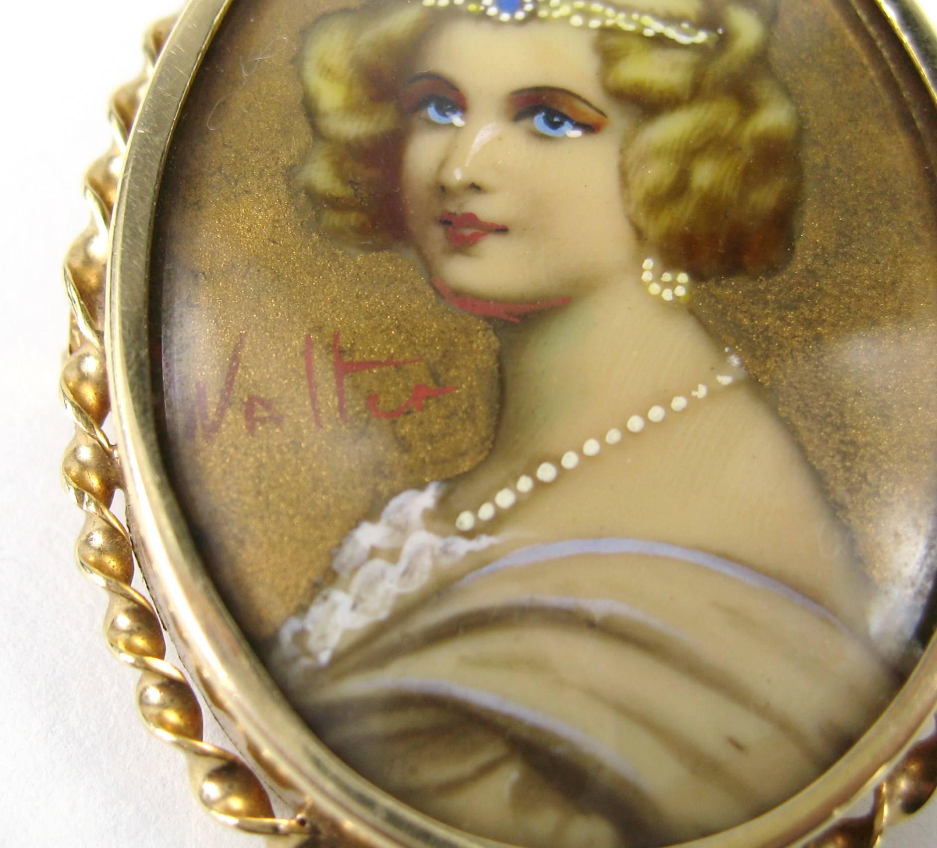 14k yellow gold antique hand painted on porcelain portrait brooch pin with a bale on the back.  The portrait is under glass depicting a stylishly dressed woman. Signed Measuring 1.75 inches or 44.49mm x 1.35 inches or 34.4 mm. This is out of a