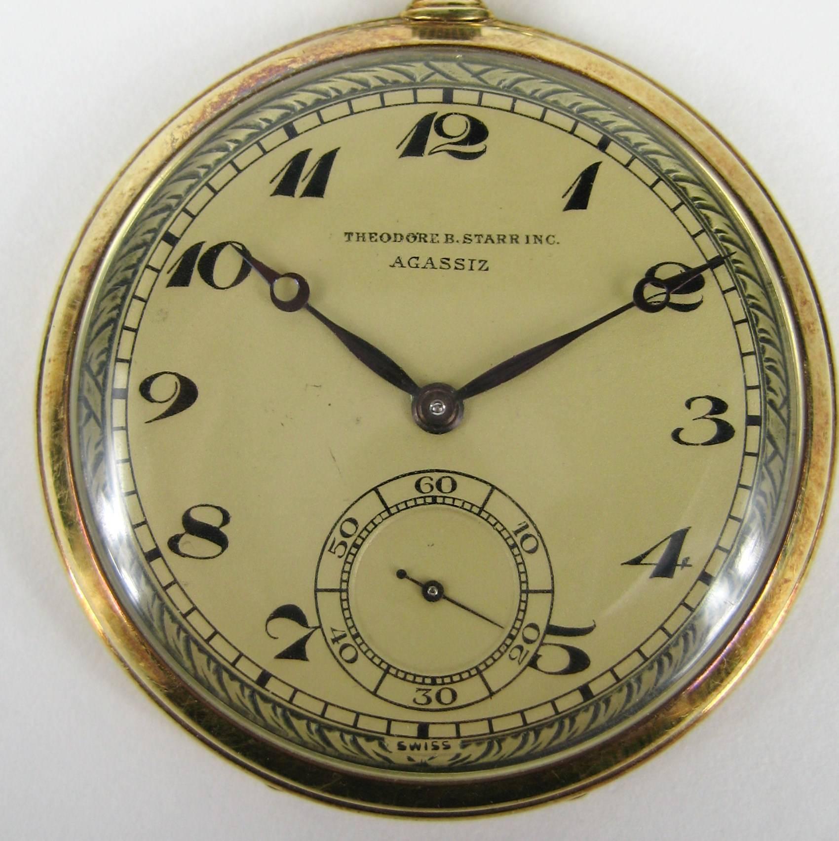 Agassiz 14k yellow gold open face pocket watch, working retailed by Theodore B. Starr, Inc. Made by AGASSIZ The dial with black Breguet numerals and subsidiary seconds. 
Watch measures 1.76 in diameter. 17 Jewels. With JT on reverse. Be sure to
