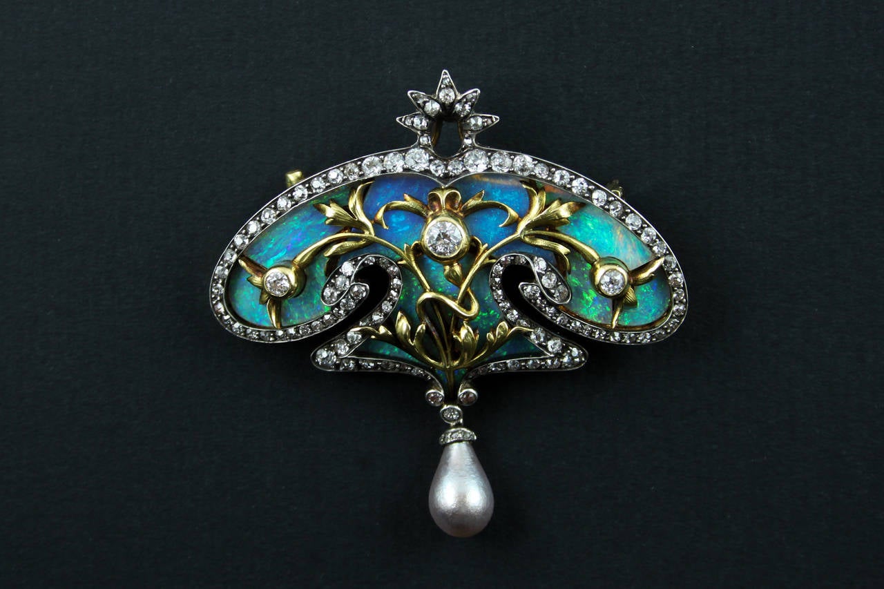 An exquisite Art Nouveau opal, old-cut diamond and natural grey pearl brooch. In silver topped yellow gold, of cartouche design. France, circa 1900.