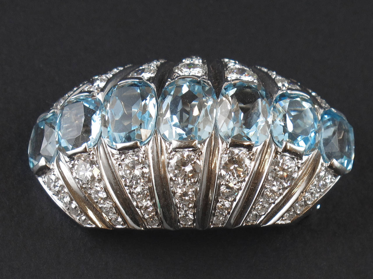 A very fine platinum and diamond brooch centering a line of fine oval-cut aquamarine. Suzanne Belperron, 1960 c.a. Maker Mark of Darde et Fils.