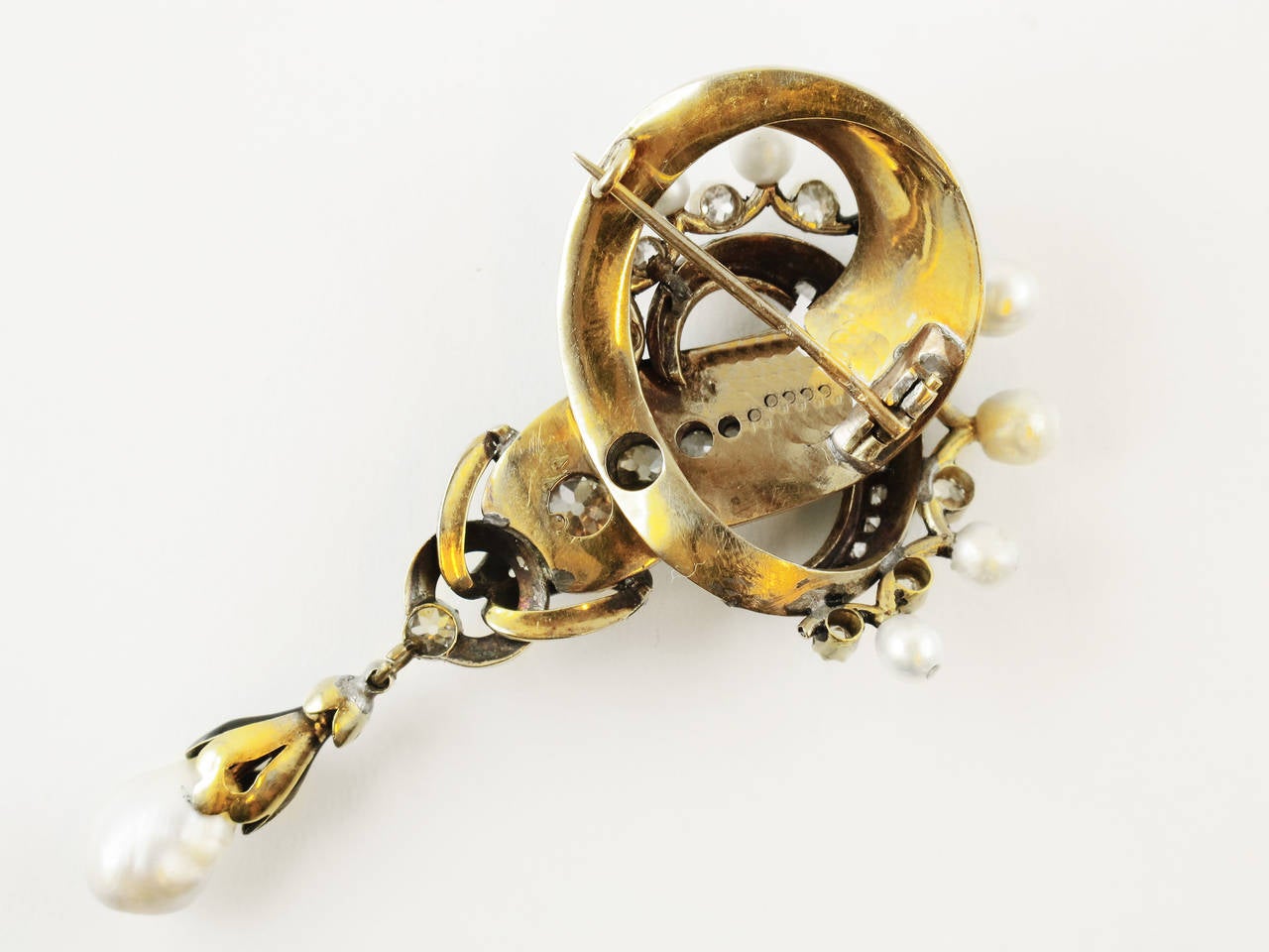 A very rare yellow gold, old-cut diamond and natural pearl brooch. Of knot design, with light blue and black enamel. The top consisting of  a Count crown made of pearl and diamond. French Hallmark, 18 kt gold. Chaumet Hallmark. 1870 c.a. The drawing