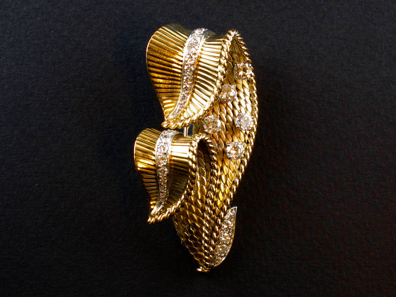 A yellow gold and diamond brooch in the shape of two leaves. Signed Mauboussin Paris, 1940 c.a.