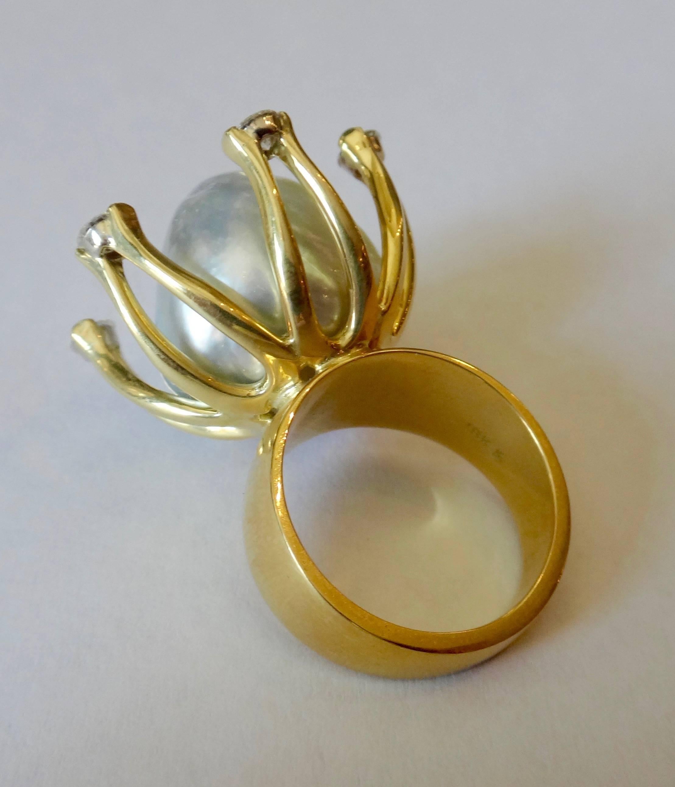 Influenced by the work of Alexander Calder is this hand fabricated 18k yellow gold cocktail ring.  Nestled within six diamond tipped arms is an 18mm baroque Tahitain pearl possessing a luminous pale gray color.  Ring size 7 and may be sized.  