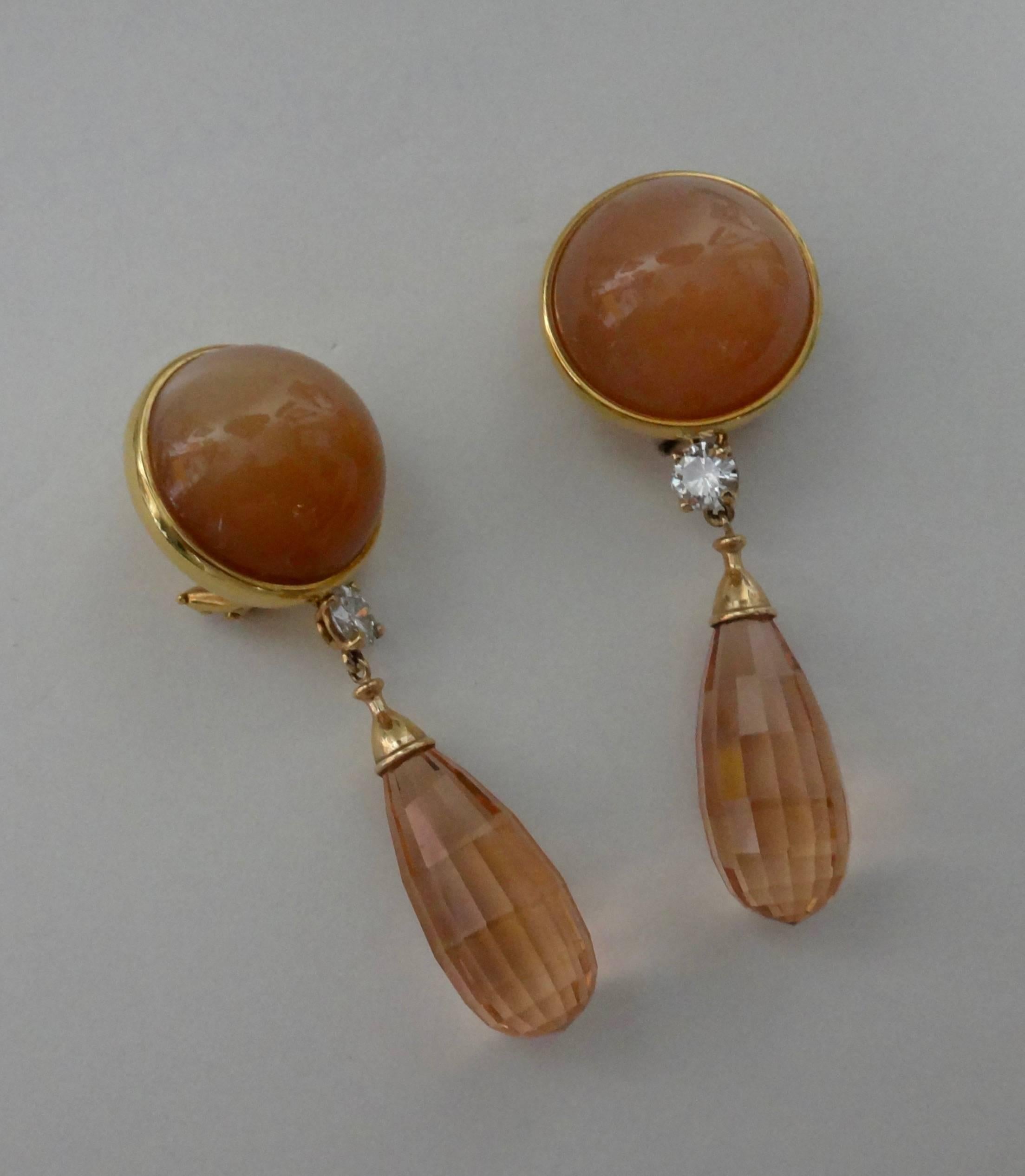 Perfectly matched, peach colored moonstones with wonderful four point stars are bezel set in 18k yellow gold.  Hanging below are diamond and large Morganite briolette drops which are removable via shepherd's hooks on the back of the moonstones. 