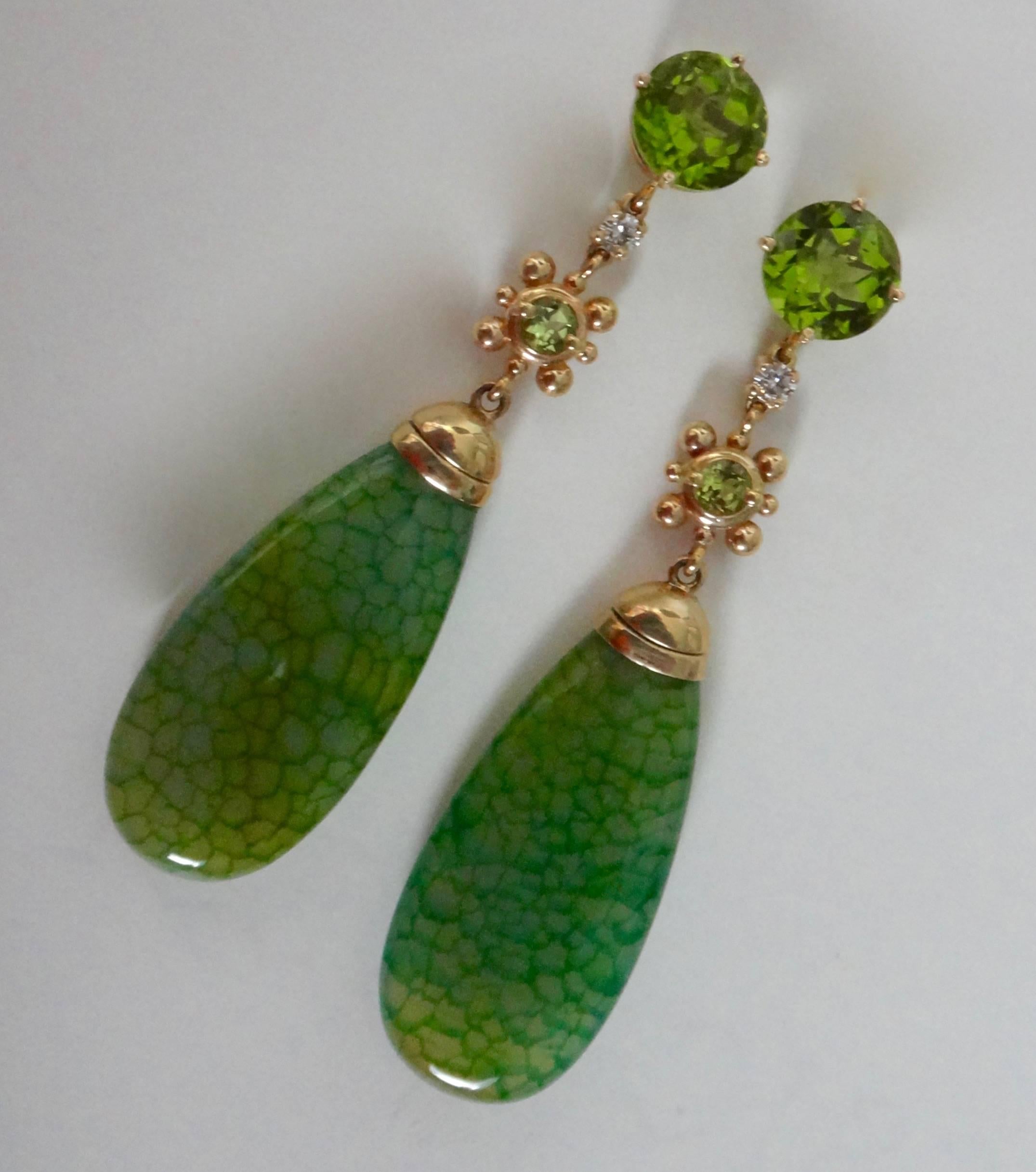 Hanging from a pair of brilliantly colored round peridots, are white diamonds, mint green Mali garnets and very unusual Dragon Skin agates.  The dark green webbing over a lighter green base color creates in these highly polished drops, a lizard skin