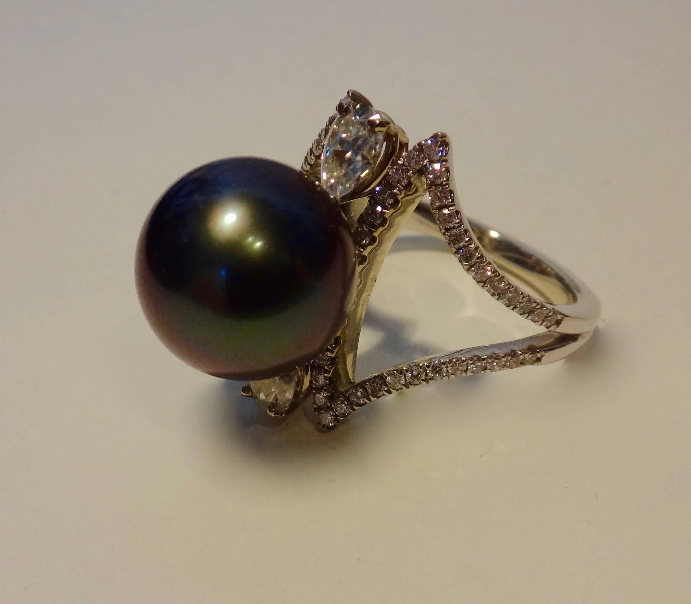 12.5mm, gem quality black Tahitian pearl with lovely pink and green highlights, is mounted in this delicate white gold ring with micro-paved diamonds and two pear shaped diamonds.  Ring size 7 1/4 and my be size up only.  