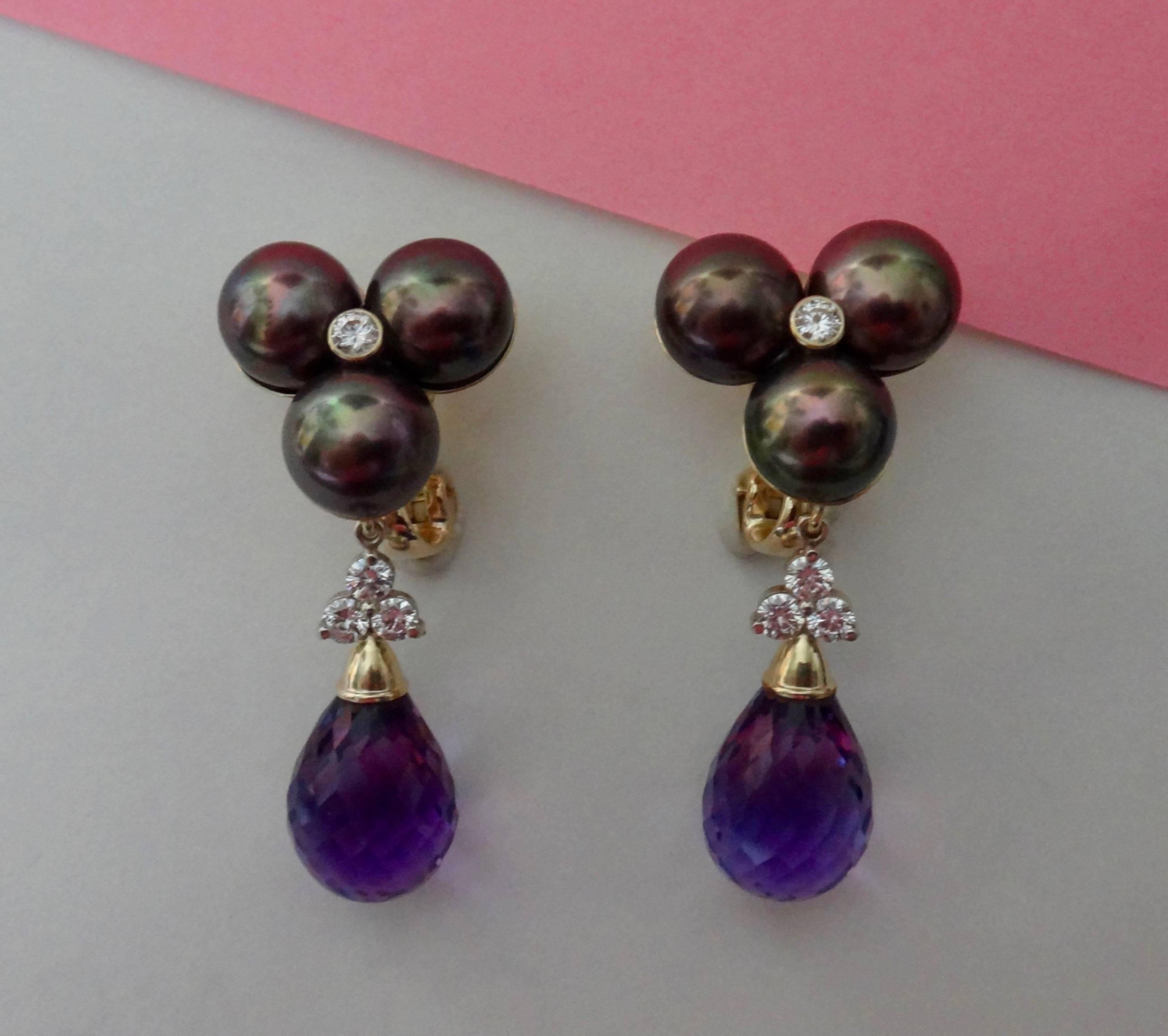 Black button pearls with pink and purple undertones are clustered together and embellished with bezel set, brilliant cut white diamonds.  Suspended from the earrings are a diamond decorated pair of perfectly matched amethyst briolette which are
