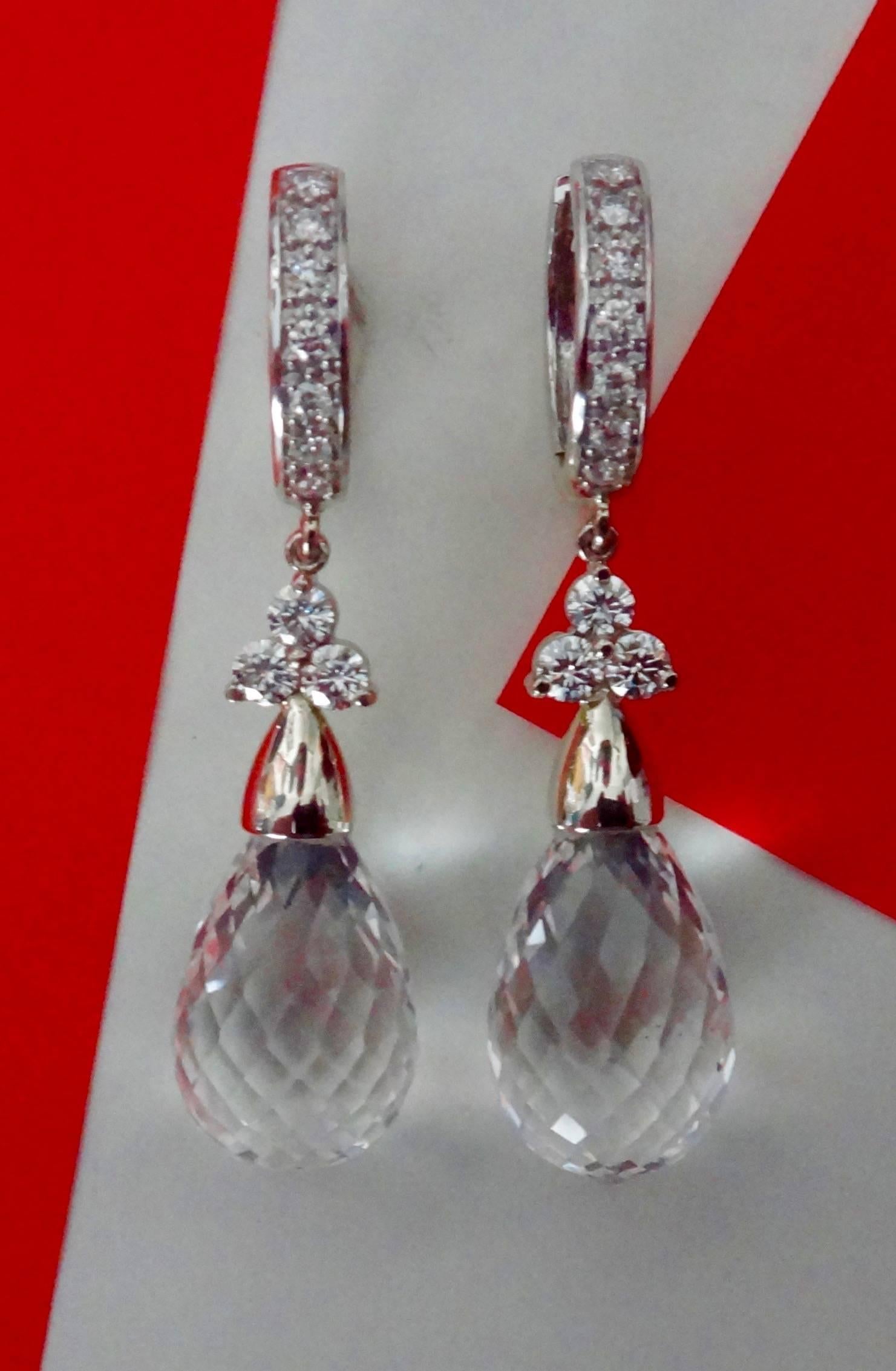 Faceted rock crystal briolette are decorated with diamonds and suspended from diamond "Huggie" style hoops in these dangle earrings.  All set in 14 karat white gold.
