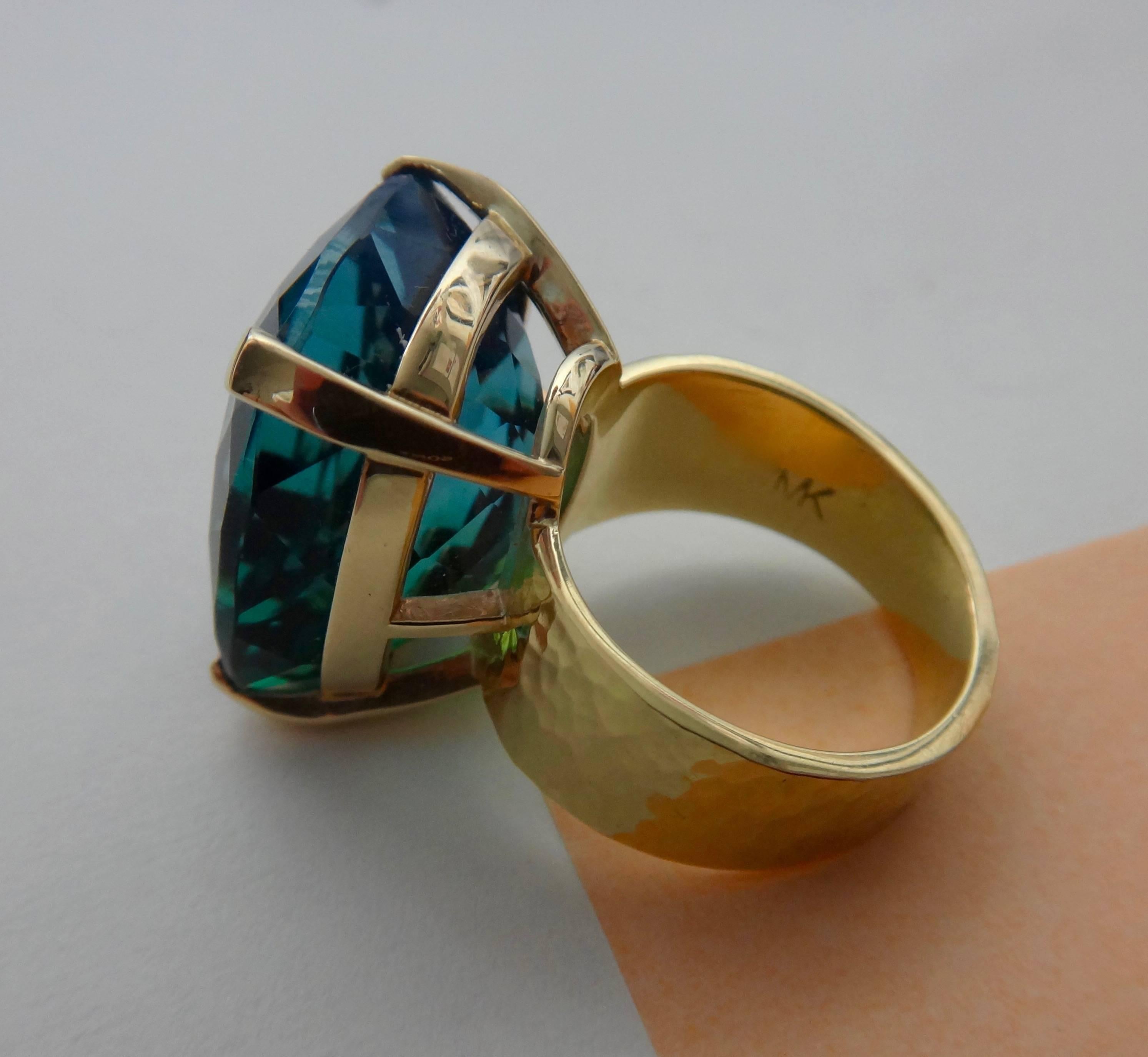 Ein höchst ungewöhnlicher Bicolor-Topas in Blau- und Grüntönen ist in einem breiten:: handgefertigten:: gehämmerten Band aus 18 Karat Gelbgold gefasst. Der 33 Karat schwere Edelstein ist facettiert in einer "Portugiesisch" Konfiguration. 