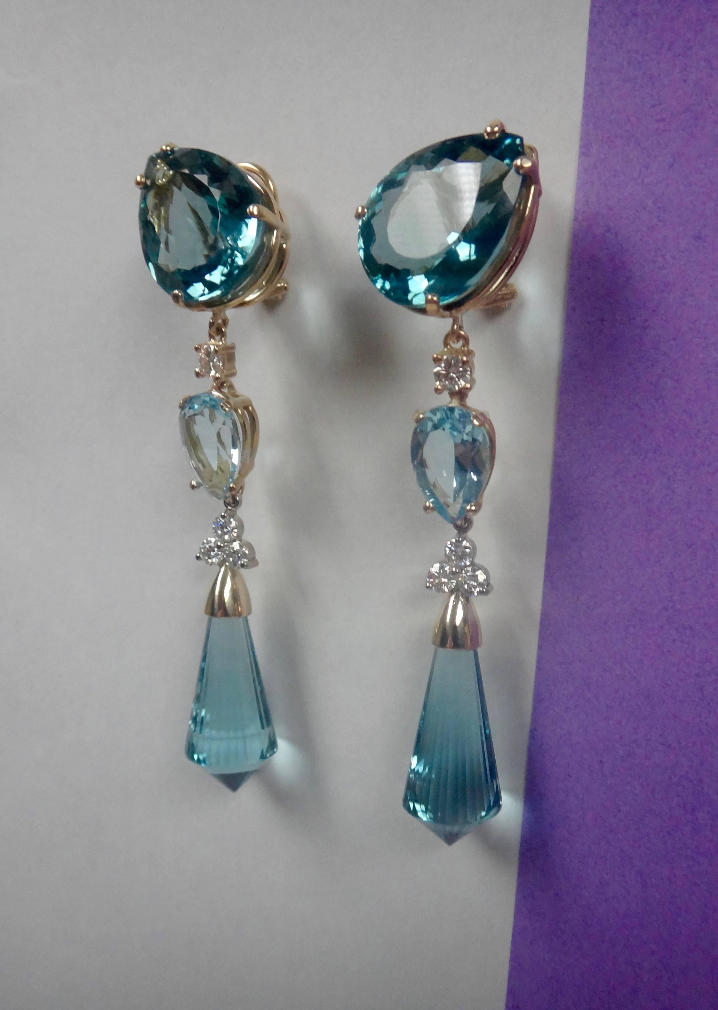 Three different shades of blue topaz are decorated with diamonds in these dramatic dangle earrings.  The briolette are lavishly faceted and terminate in points rather that in the more traditional rounded shape.  There one-of-a-kind earrings come