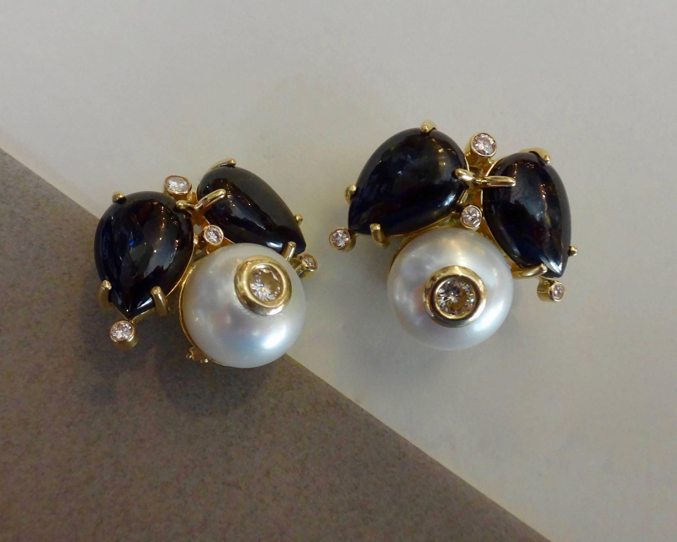 Luxurious, cabochon cut black spinels are combined with white button pearls studded with bezel set diamonds along with other diamond accents in these bespoke button earrings. They are a generous size without being ostentatious.  Posts with omega
