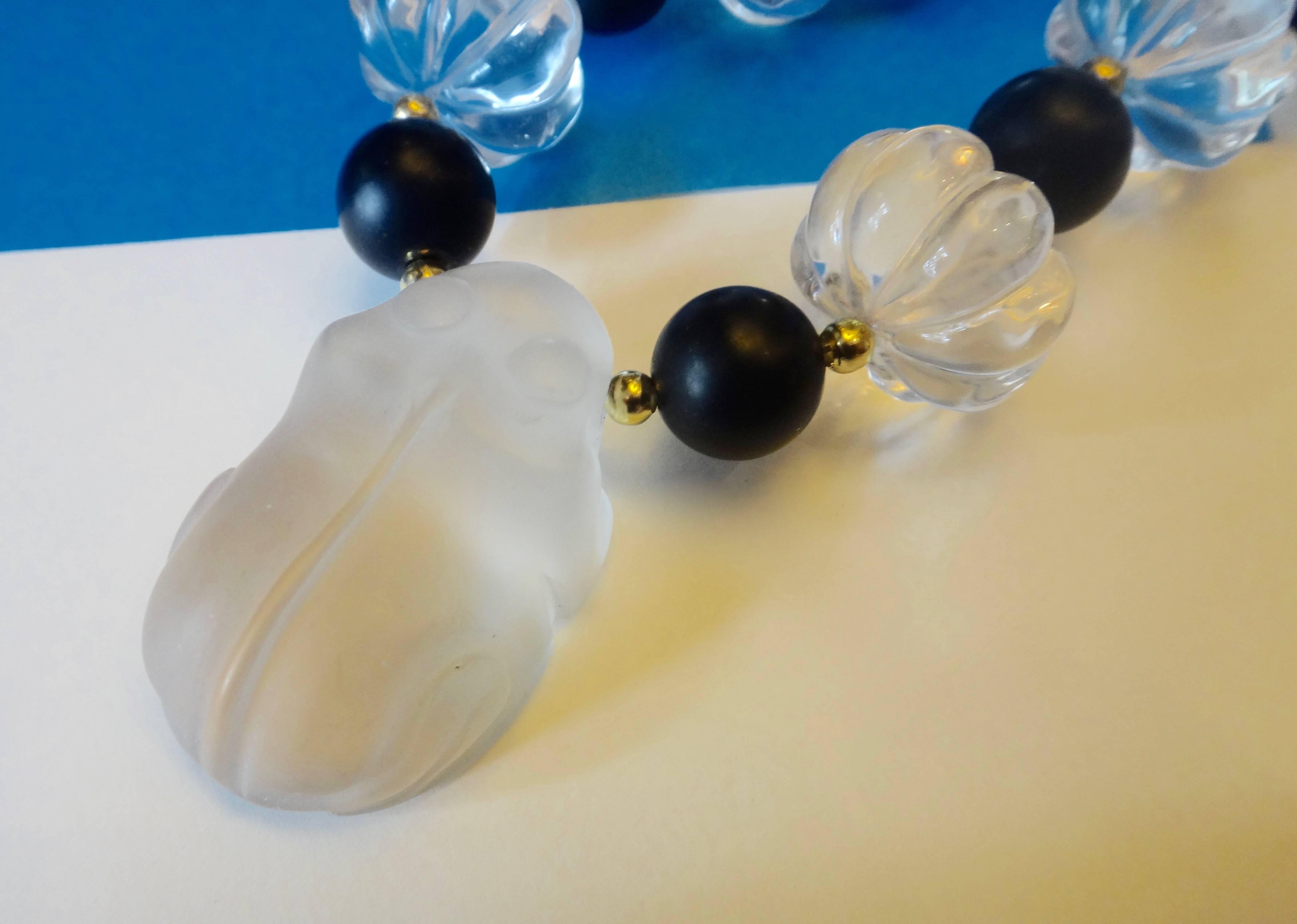 A sweetly sleeping frog carved from rock crystal in a frosted finish is the centerpiece of this necklace.  Further embellishing the piece are six melon carved rock crystal beads along with matte finished black onyx beads.  The necklace is finished