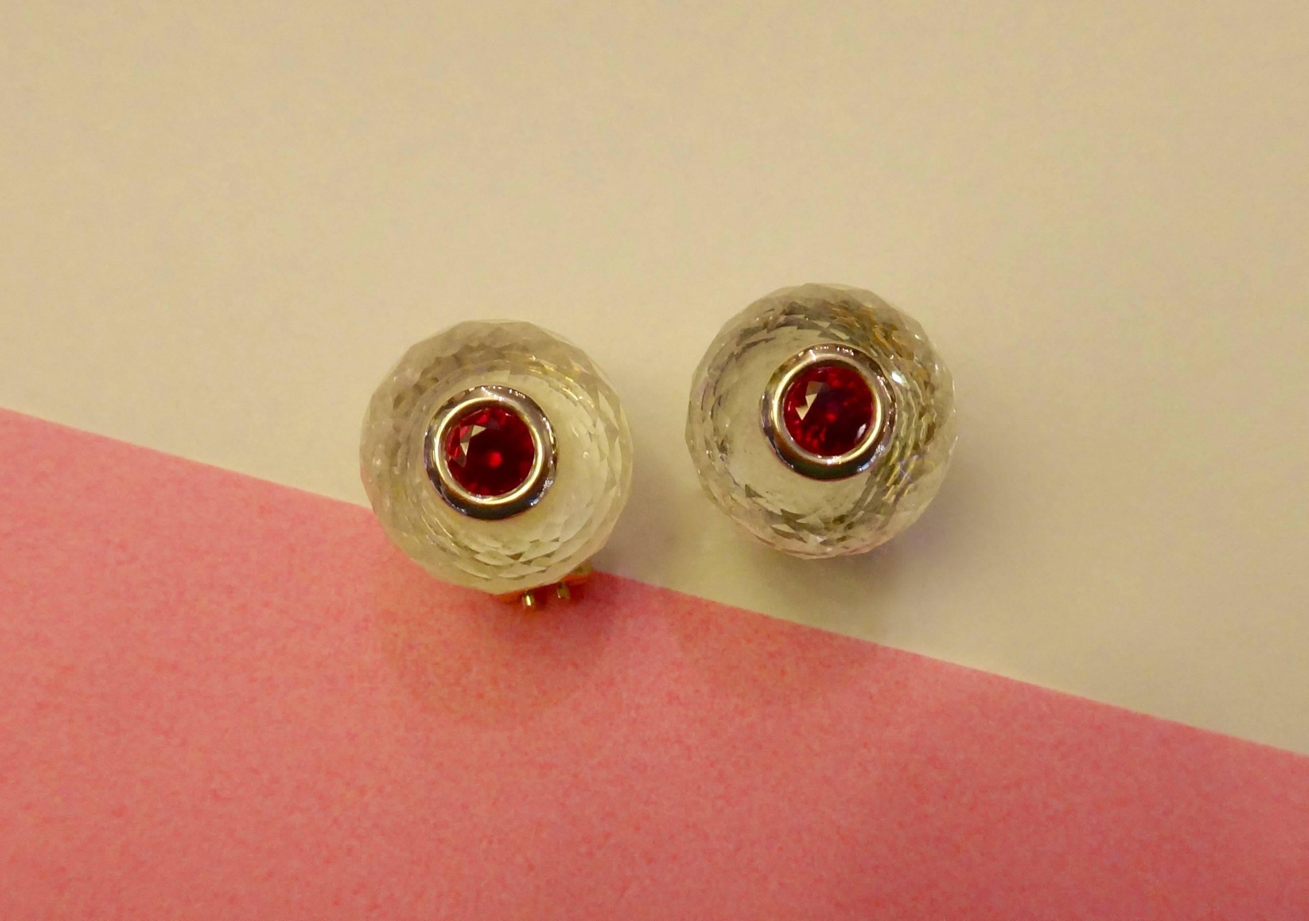 Rondelles of faceted rock crystal are decorated with bezel set, brilliant cut rubies in these stunning stud earrings.  18k yellow gold posts with omega clip backs.  