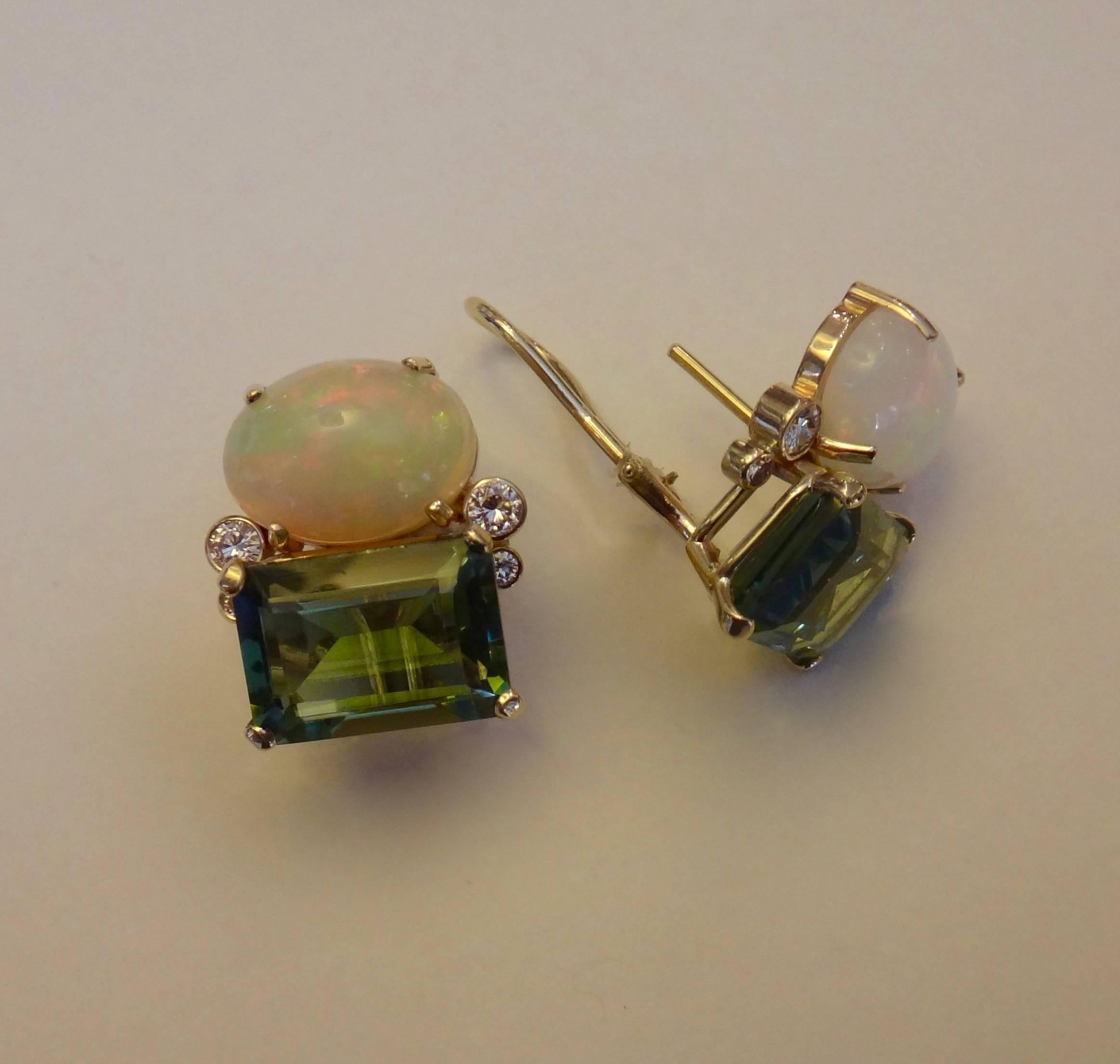 A lively pair of cabochon opals originating from Ethiopia are paired with emerald cut green beryls and further accented with diamonds in these "Due Pietra" earrings. The opals possess a full spectrum of colors are including shades of