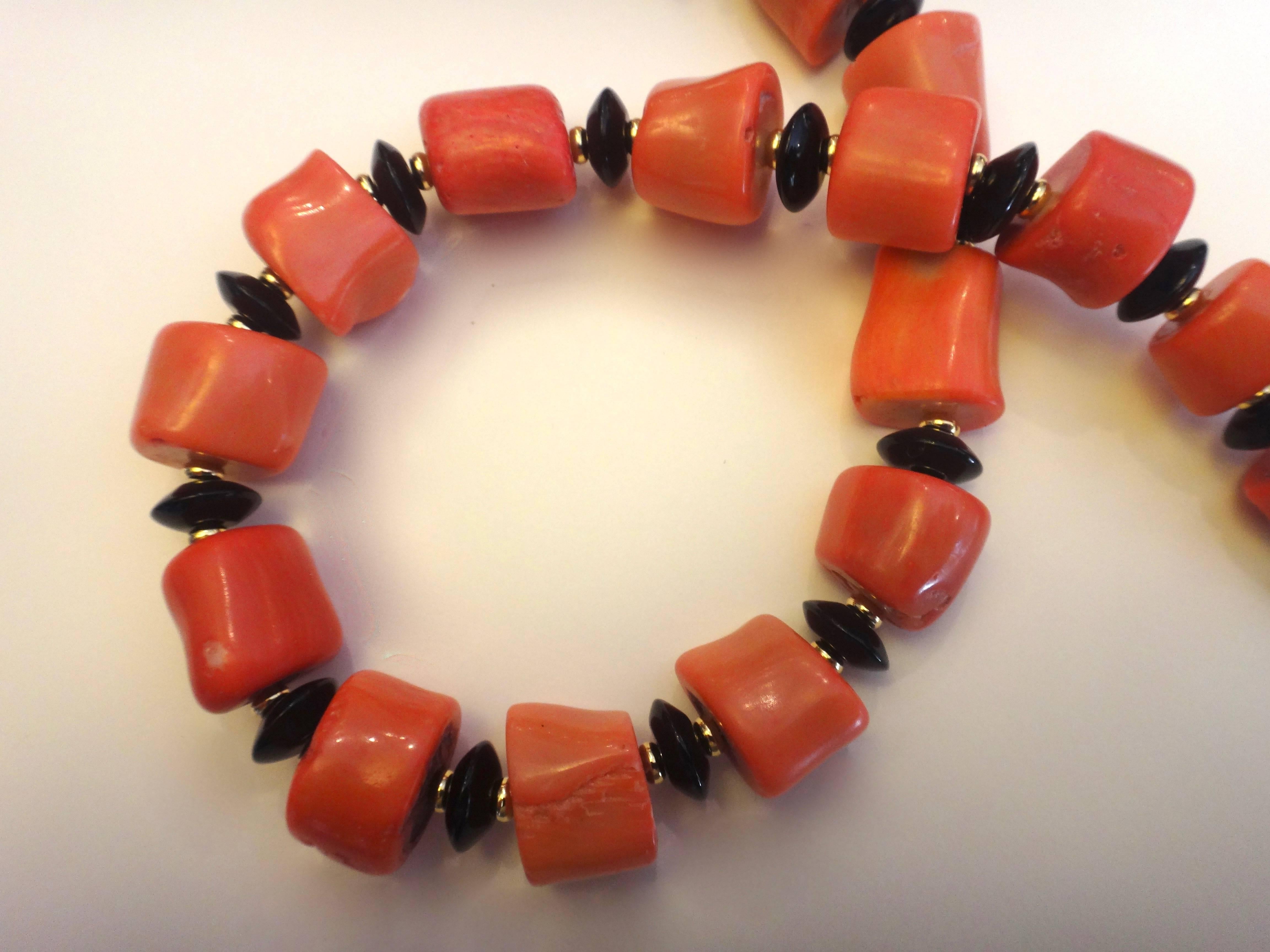 Slices of salmon colored branch color form beads in this nugget necklace.  Complimenting the coral in a very classic color combination, are rondelles of black onyx.  Tiny gold rondelles add interest.  The necklace is finished with a vermeil hook