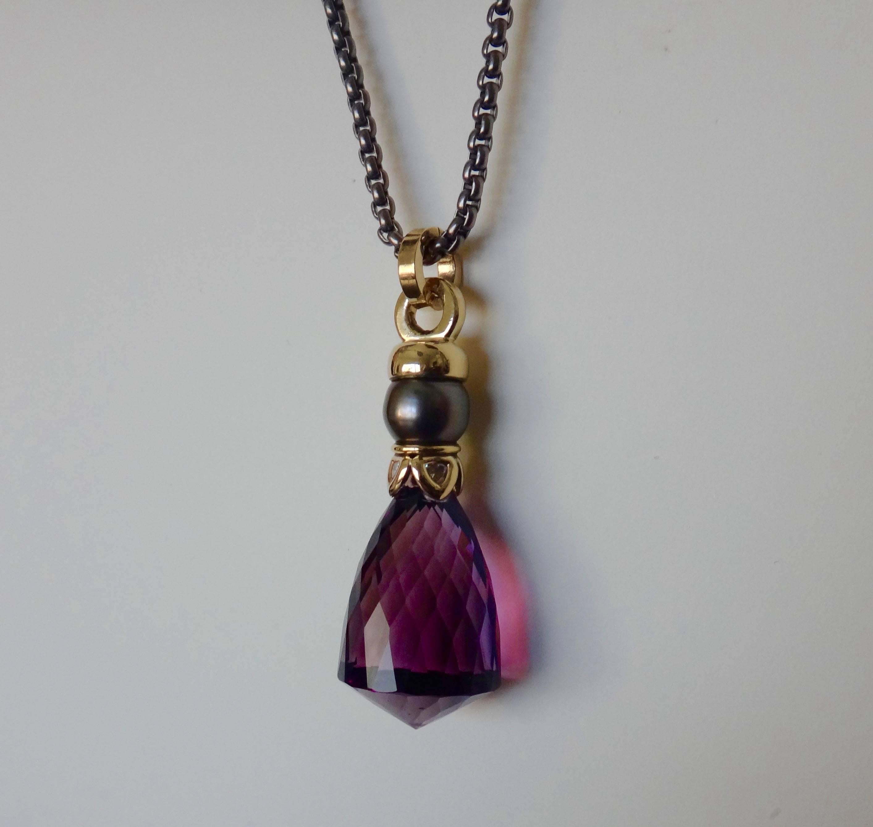 A dramatically shaped and faceted briolette is featured in this unique pendant.  Decorating the amethyst is an end cap composed of a black Tahitian pearl and bezel set, trillion shaped white diamonds.  The pendant hangs from a 30 inch titanium chain