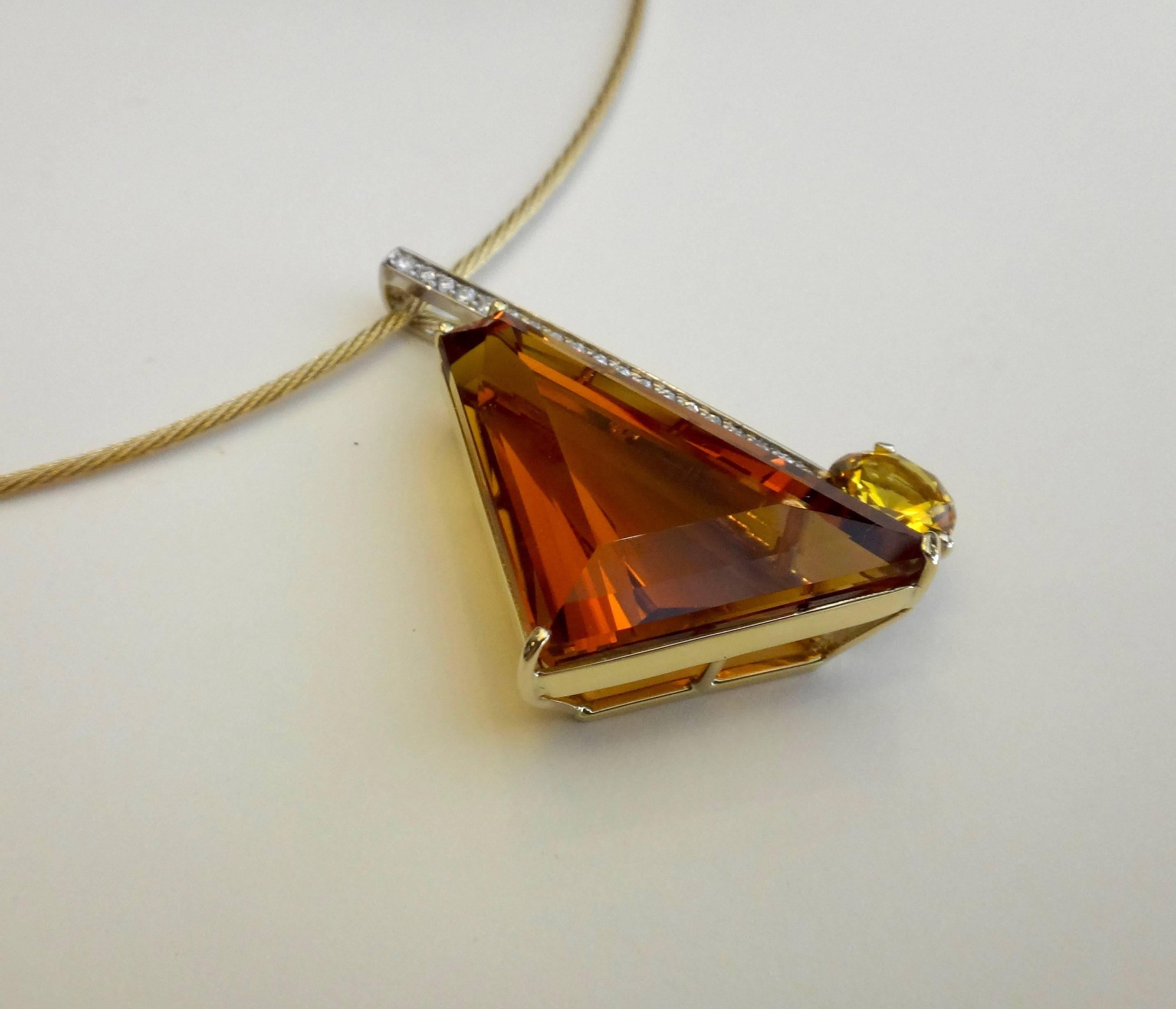 A fantasy cut Madiera Citrine is paired with a brilliant cut golden citrine in this geometric pendant.  Adding structure and interest to the piece is a white gold bar pave set with white diamonds.  The pendant hangs from a 16 inch, 14k yellow gold