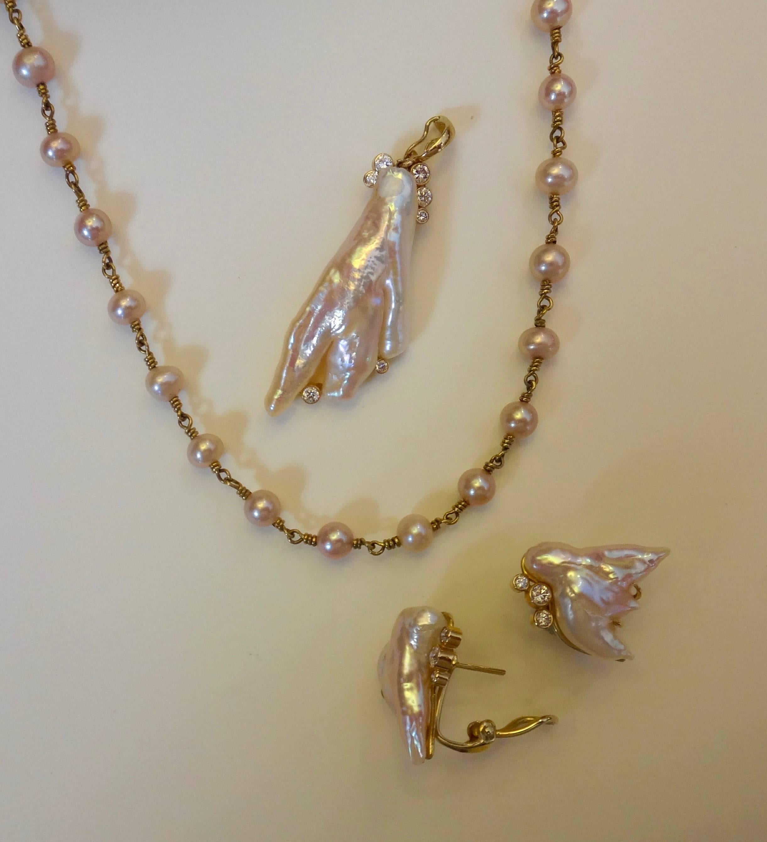 Three highly baroque freshwater pearls were the inspiration for this Angel Wing pearl suite consisting of pendant, necklace and earrings.  The pearls are a delicate shell pink color and possess high luster.  The white diamonds are bezel set.  All