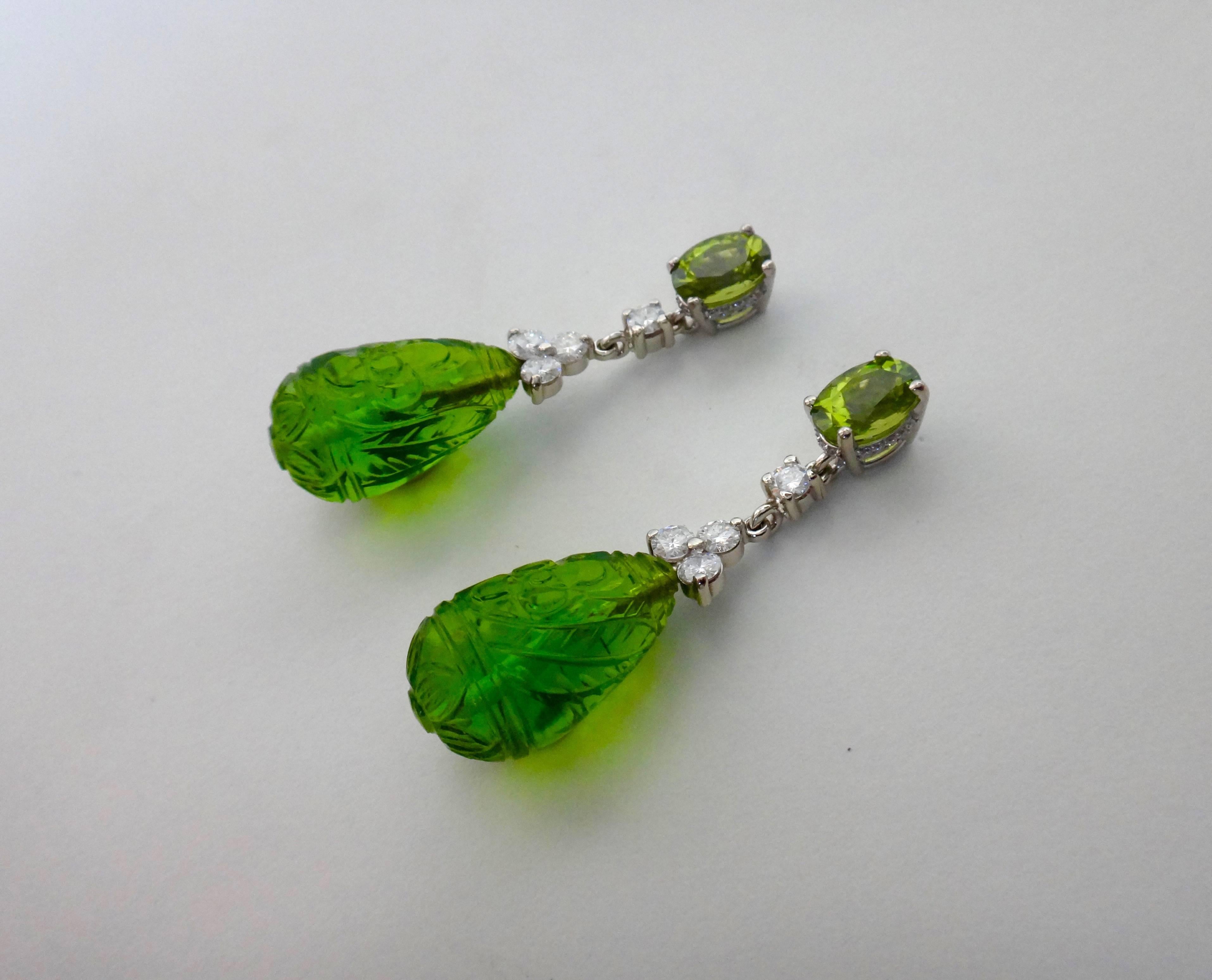 Oval cut peridots support dangles of white diamonds and carved green fluorite drops from India.  The scintillating green gems are set in white gold mountings with micro-pave detail around the bearings of the peridots.  The earrings come with posts