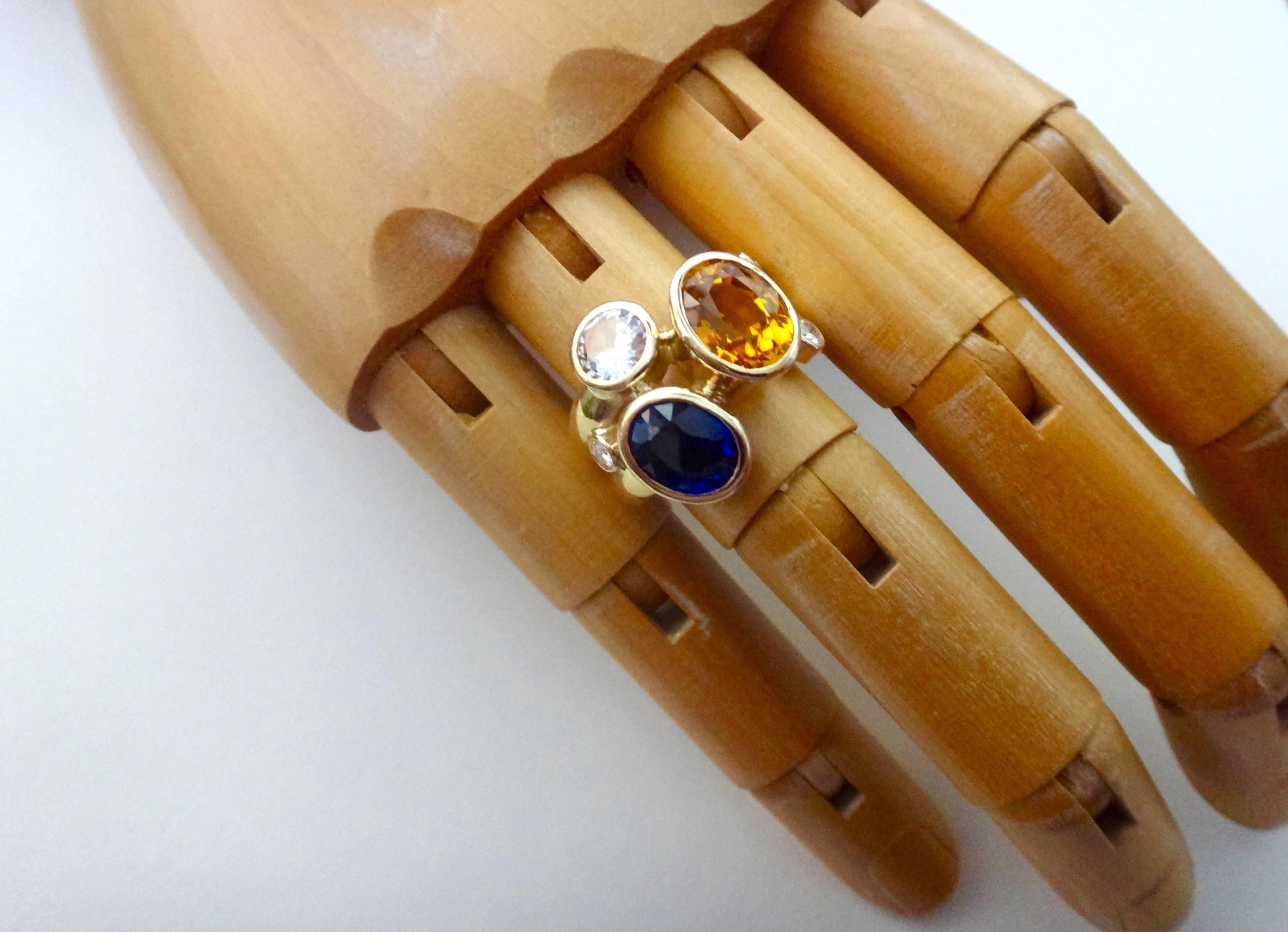 Oval cut and intense yellow and blue sapphires along with a brilliant cut silver sapphire are combined in this double 