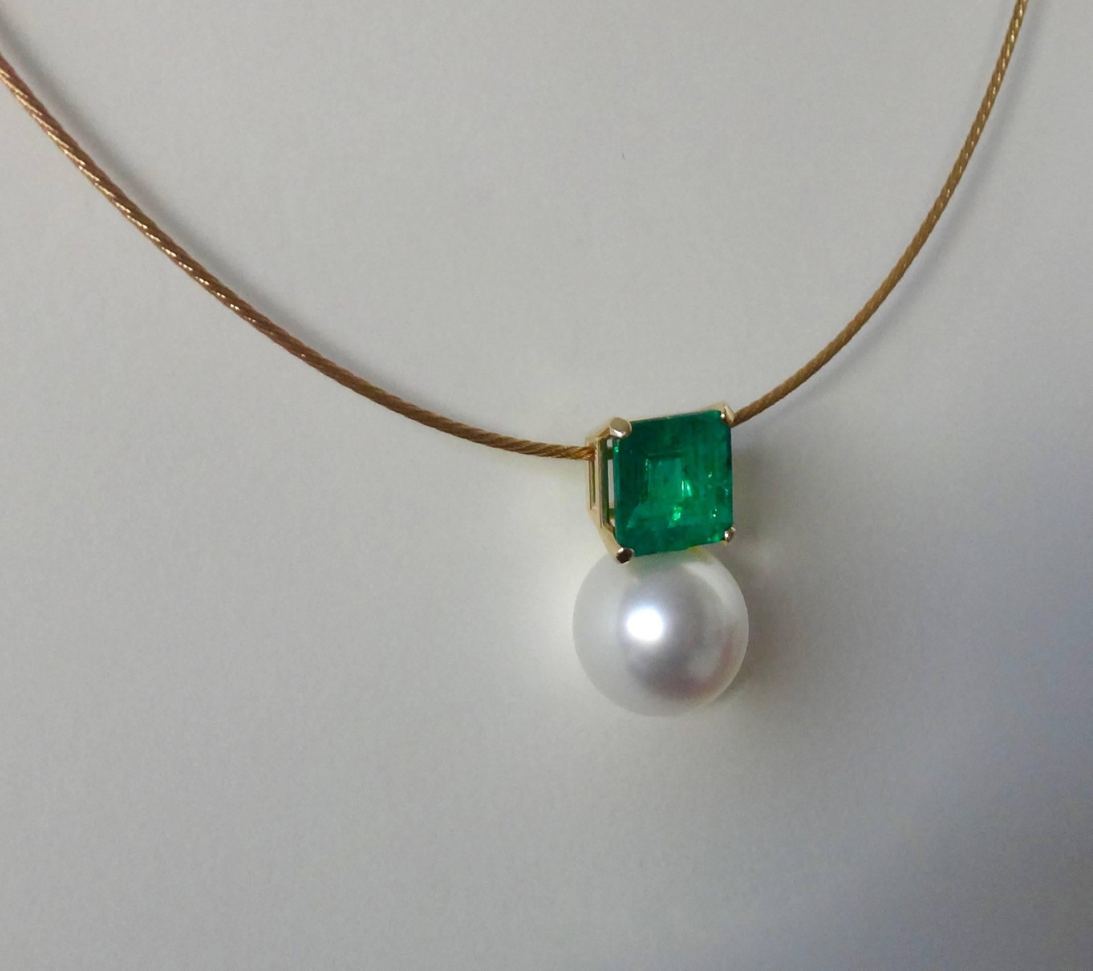 A square cut emerald of 6.41 carats is paired with a 15.5 millimeter, gem quality Paspaley South Seas pearl in this uncomplicated and elegant pendant.  The flashy emerald is of Brazilian origin, has some inclusions typical of the gem and possesses a