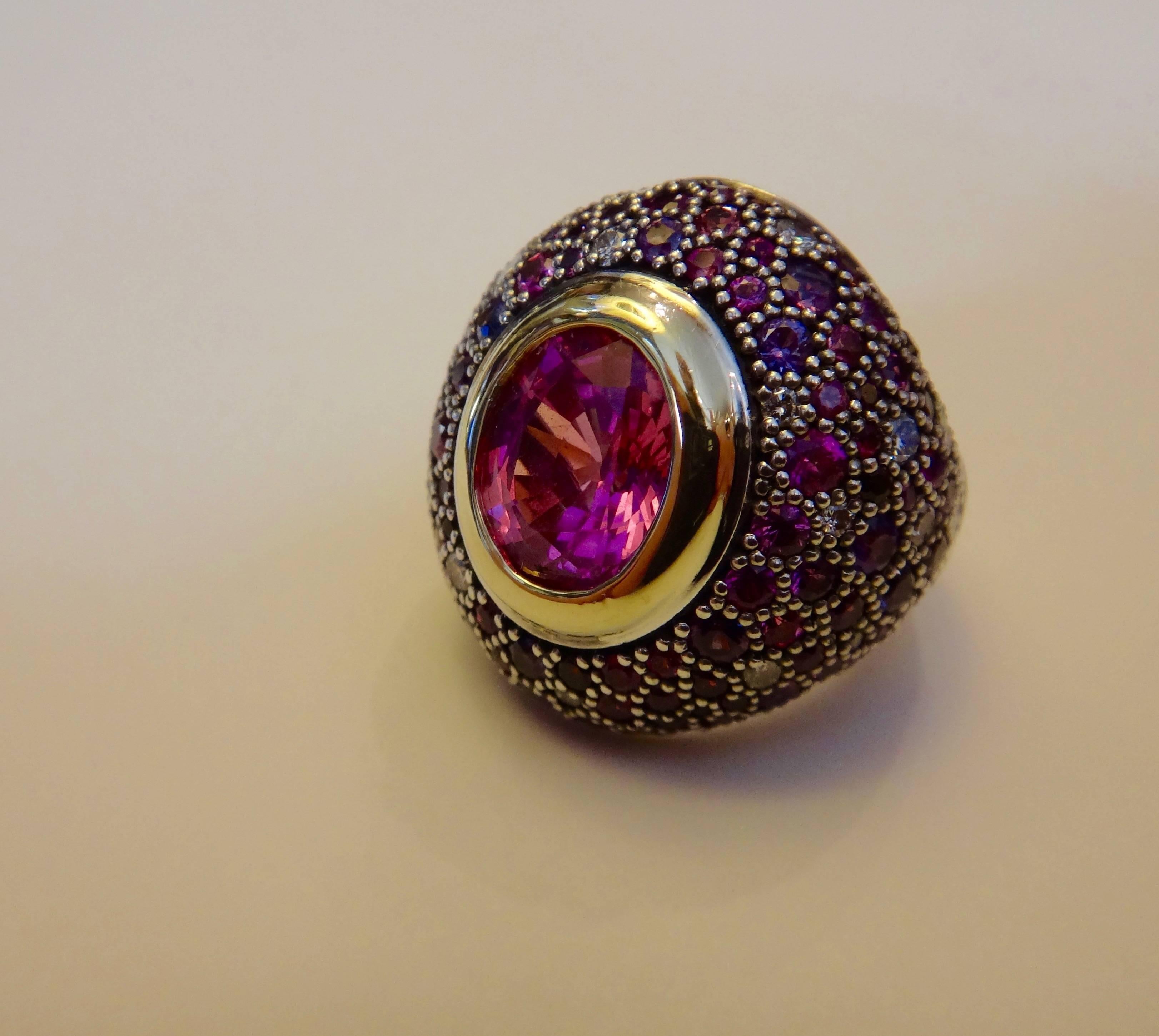 A large and exceptionally well cut oval shaped African pink sapphire is featured in this impressive dome ring.  The 