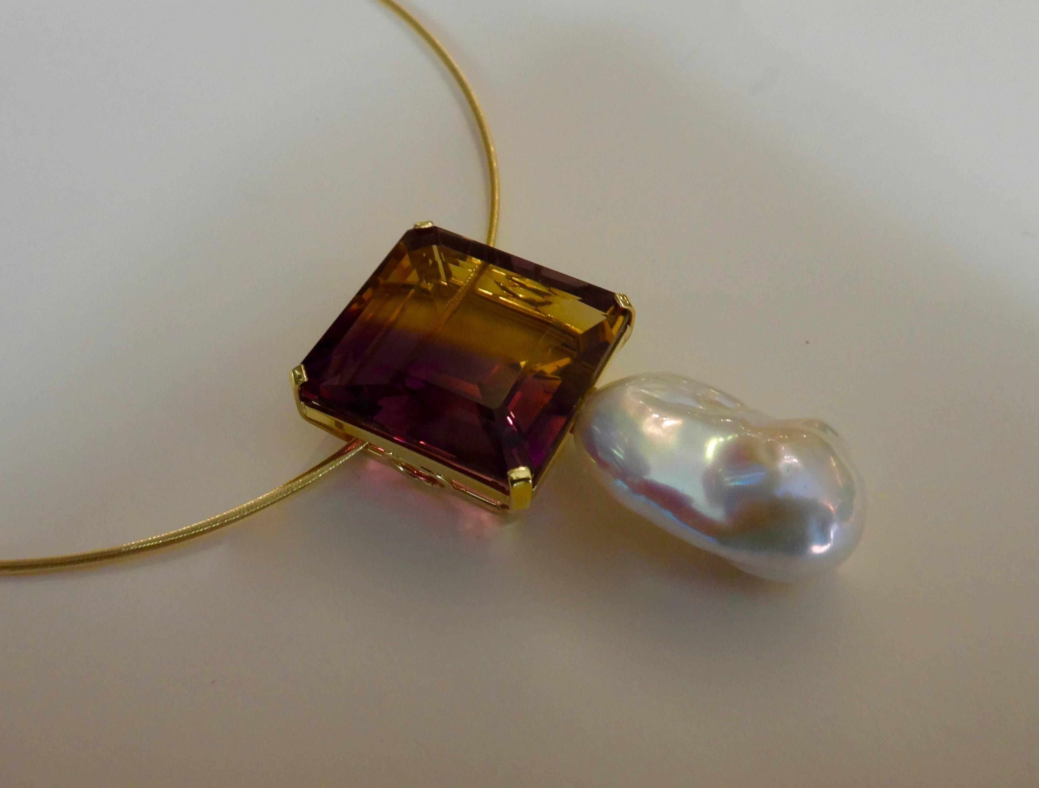A ginormous ametrine of 56.66 carats is paired with a white baroque cultured pearl in this bold statement pendant.  Ametrine is a naturally occurring variety of quartz.  It is a mix of amethyst and citrine with zones of purple and yellow or orange. 