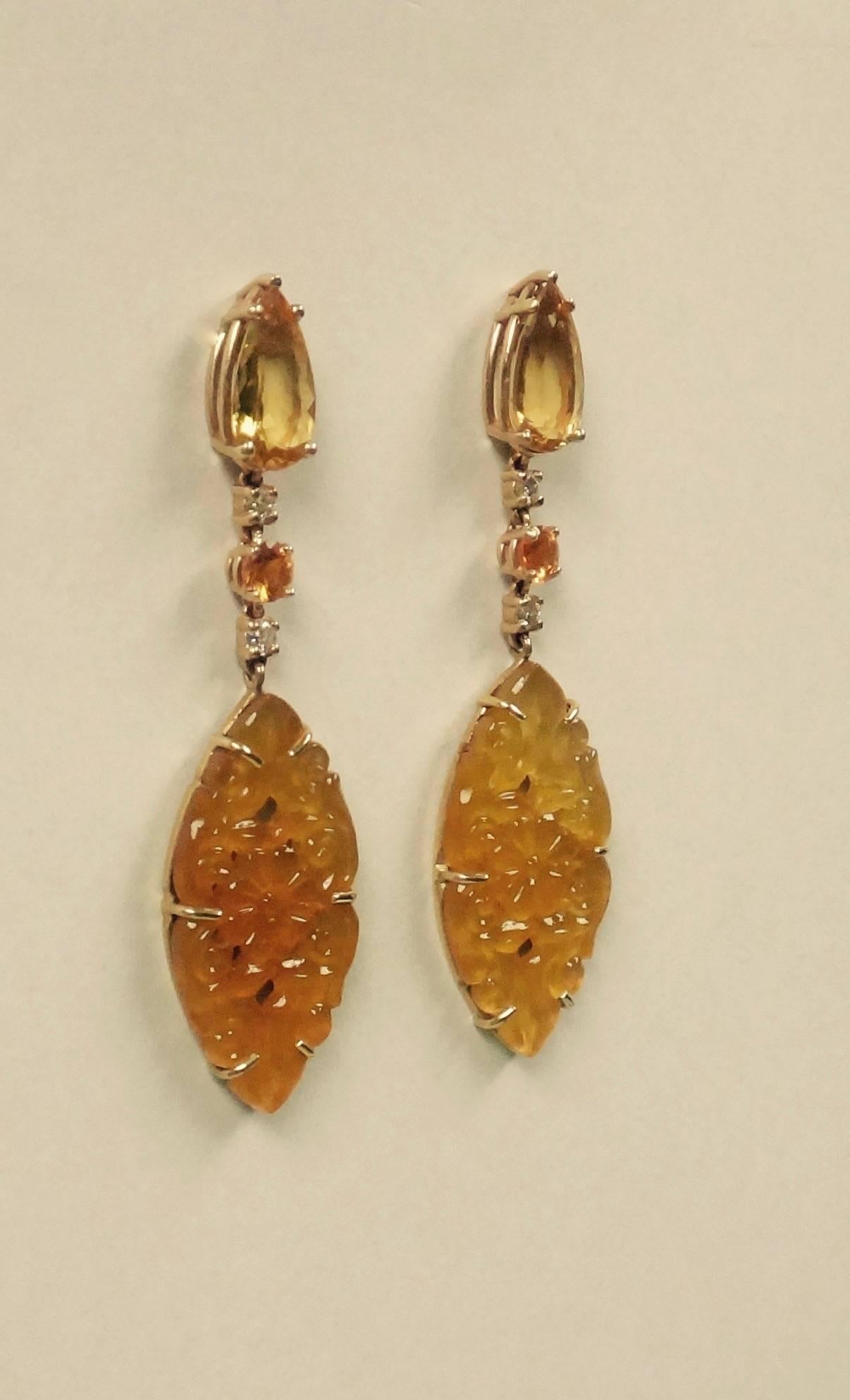 Dramatic dangle earrings consisting of pear shaped golden beryls, brilliant cut diamonds, bright yellow sapphires and exceptionally carved yellow onyx navettes.  All set in 18k yellow gold.  The navettes have been backed in 24k yellow gold to