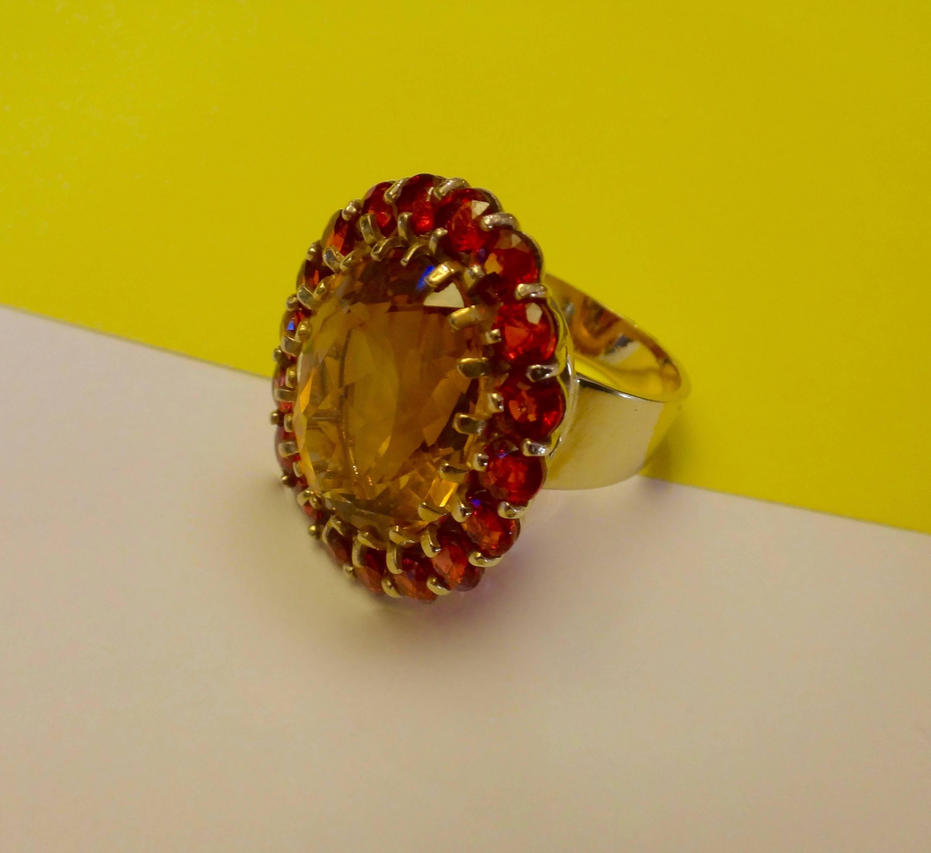 Autumnal colors of golden citrine and a collection of perfectly matched orange sapphires comprise this bold and dramatic cocktail ring.  The mounting is hand fabricated is 18k yellow gold.  The ring is a size 7 and is readily sizable.  