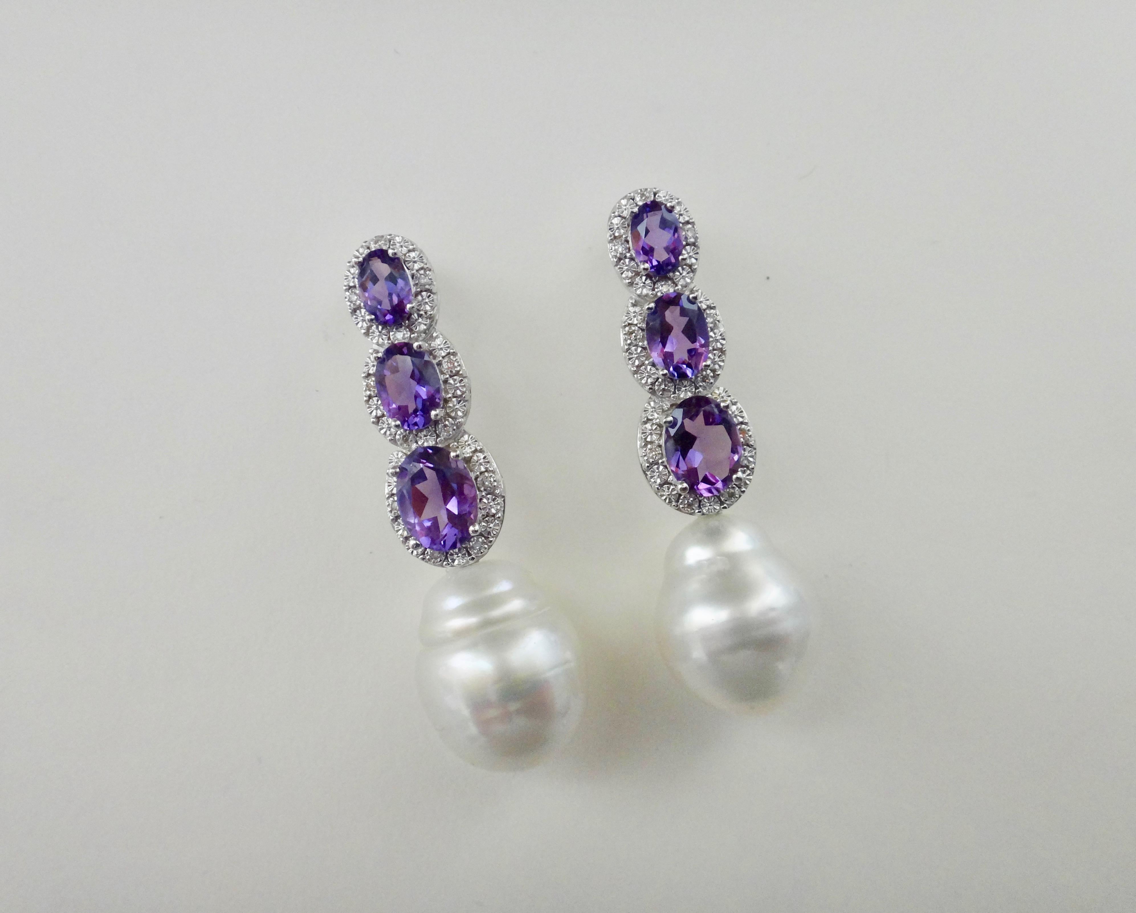 Amethyst in oval shapes and graduated in size are surrounded with micro-pave white diamonds in these white gold dangle earrings.  The drops are finished with baroque, gem quality Paspaley South Seas pearls.  The earrings come with posts and extra