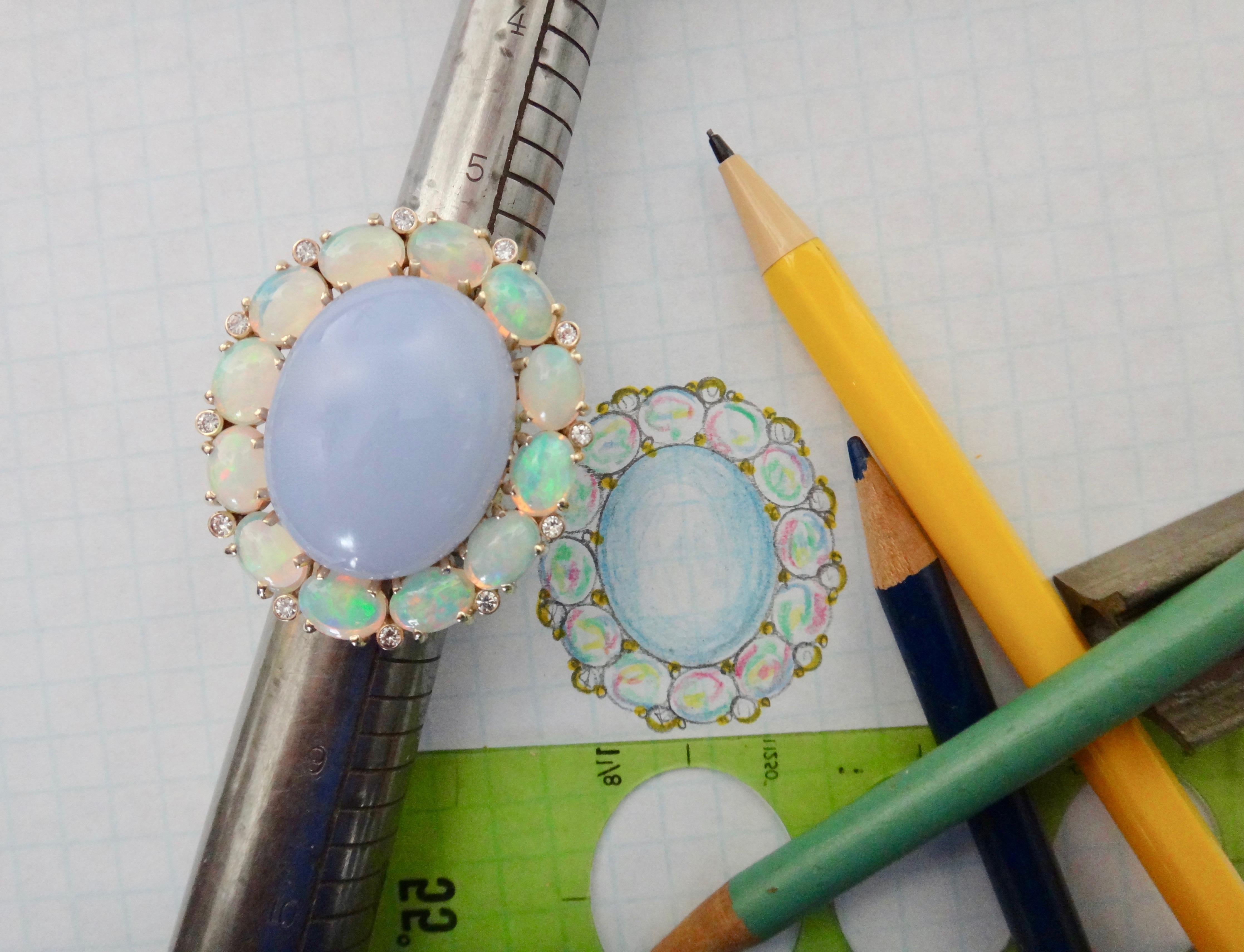 A delicately colored blue chalcedony with a delicious polish is the centerpiece of this dinner ring.  The cabochon is surrounded by 12 Ethiopian opals with a full range of colors including blue, green, pink and orange.  Spaced between the oval