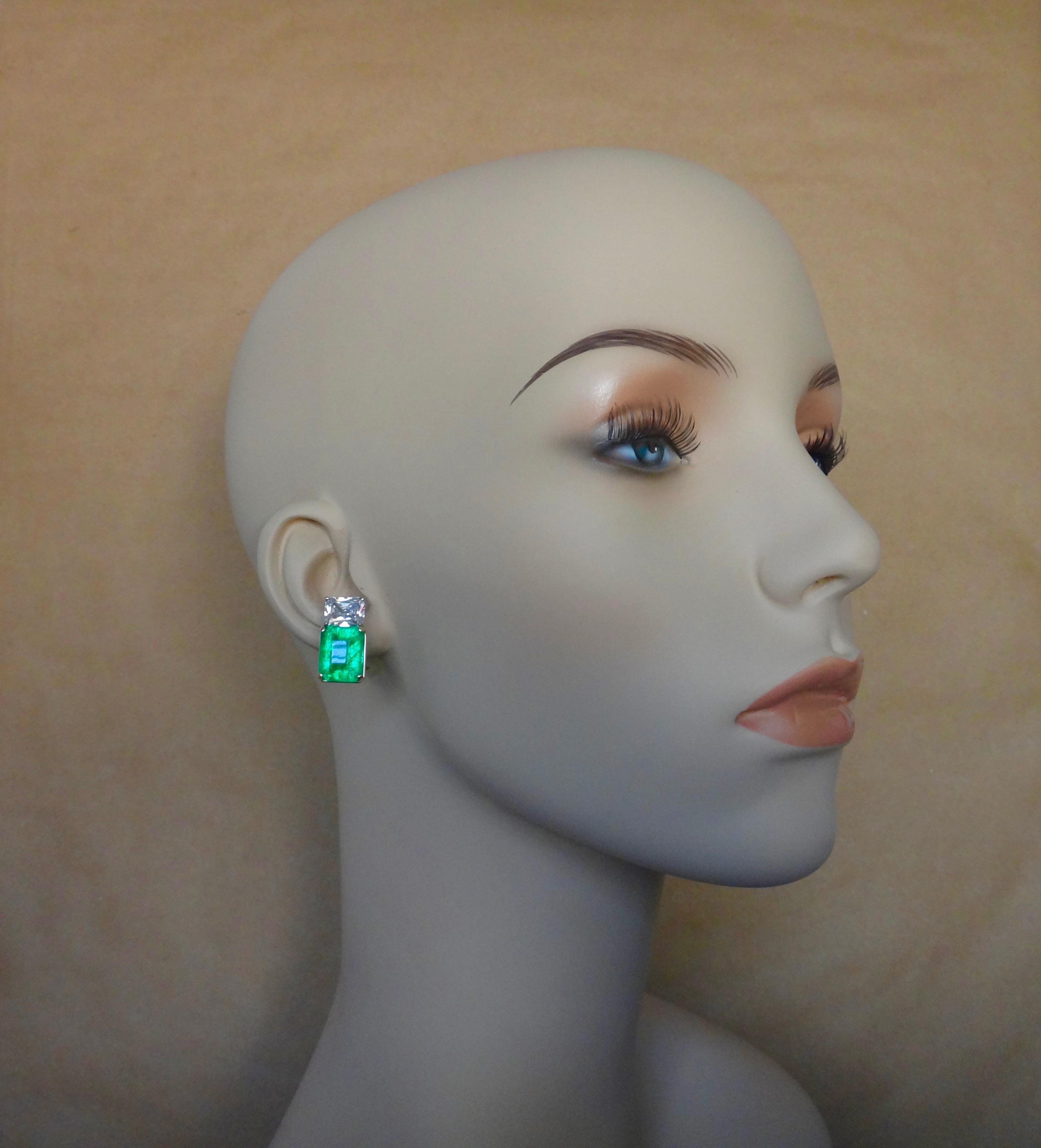 A pair of beautifully matched African emeralds are complimented by a pair of radiant cut silver sapphires in these classic and elegant earrings.  The emeralds possess a luscious 