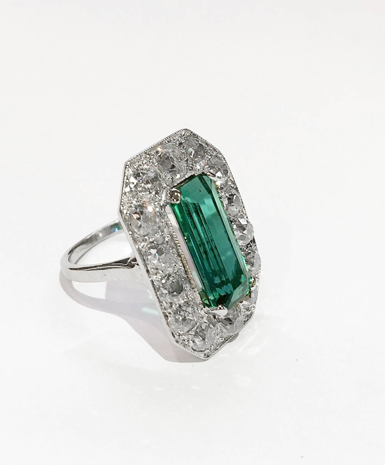 An Art deco platinum ring set with old European cut diamonds and a long rectangular green tourmaline in the center. 
Weight of diamonds : about 4 carats. 
Weight of the tourmaline : 4,80 carats
Size : 7 sizable. 
Circa 1920