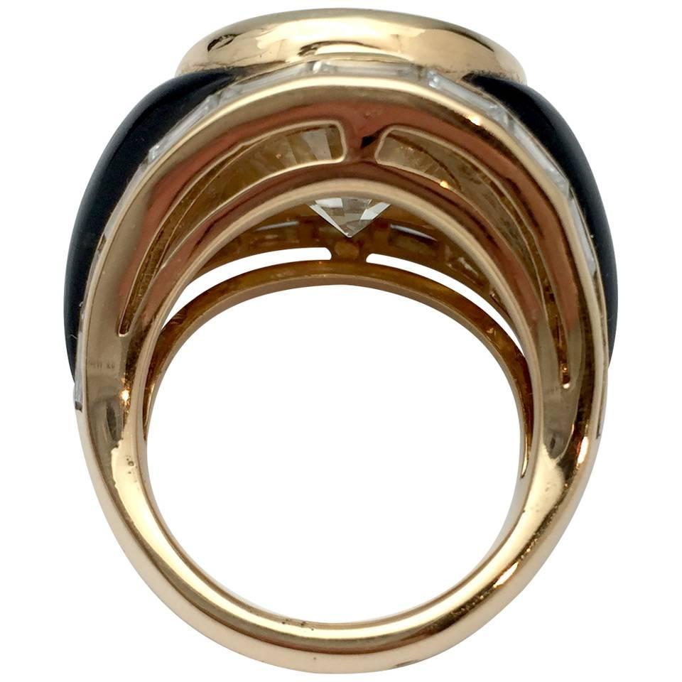 Yellow gold ring set with a 10.28 carats brilliant-cut diamond in a bezel setting.
Each side of the center is inlaid with a black onyx piece.
The borders of the ring are underlined with a row of baguette-cut diamond.
French gemological certificat