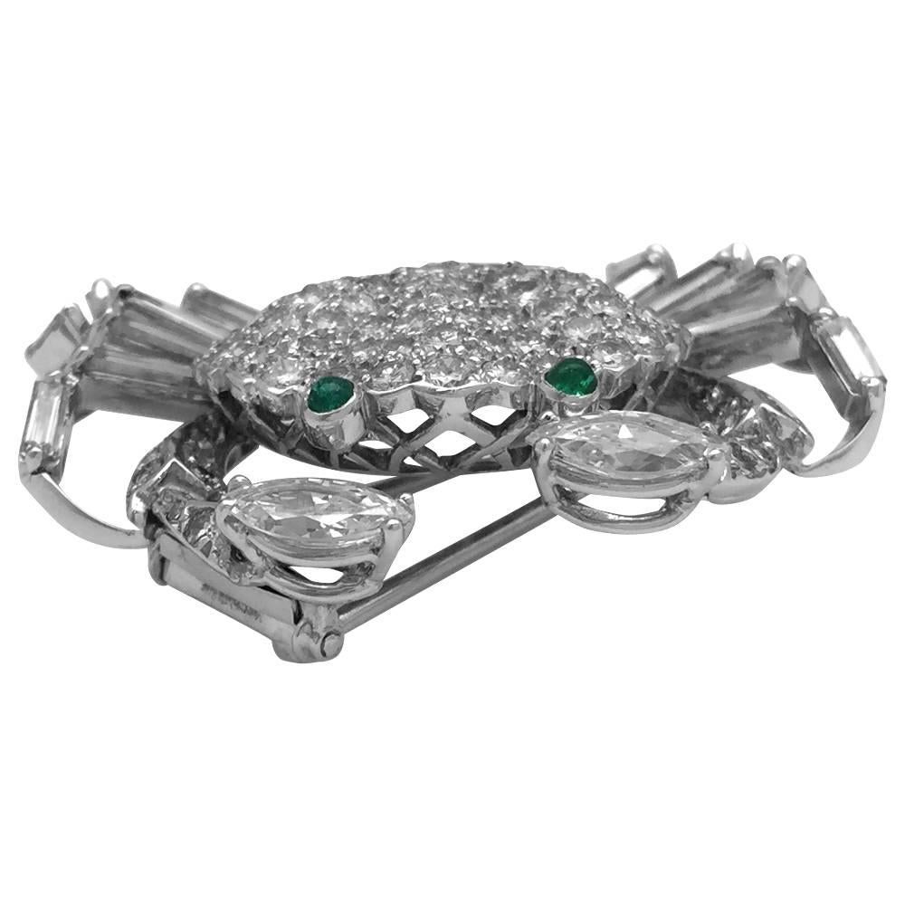 White gold crab brooch all set with brilliant-cut and baguette-cut diamonds.
The crab claws are represented by two marquise-cut diamonds.
The eyes are set with cabochon-cut emeralds.
Very fine and delicate art Craft work from the 80's.
Width : 35 mm