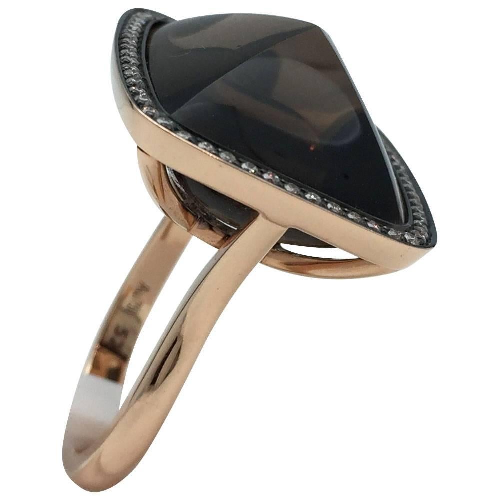 A 750/000 partially blackened pink gold ring centered with a sugarloaf smoky quartz and surrounded with brillant cut diamonds. Bellow the quartz is a link of an anchor chain set with brilliant cut diamonds. 
Finger size: 6
Length : 24 mm.
Width : 20
